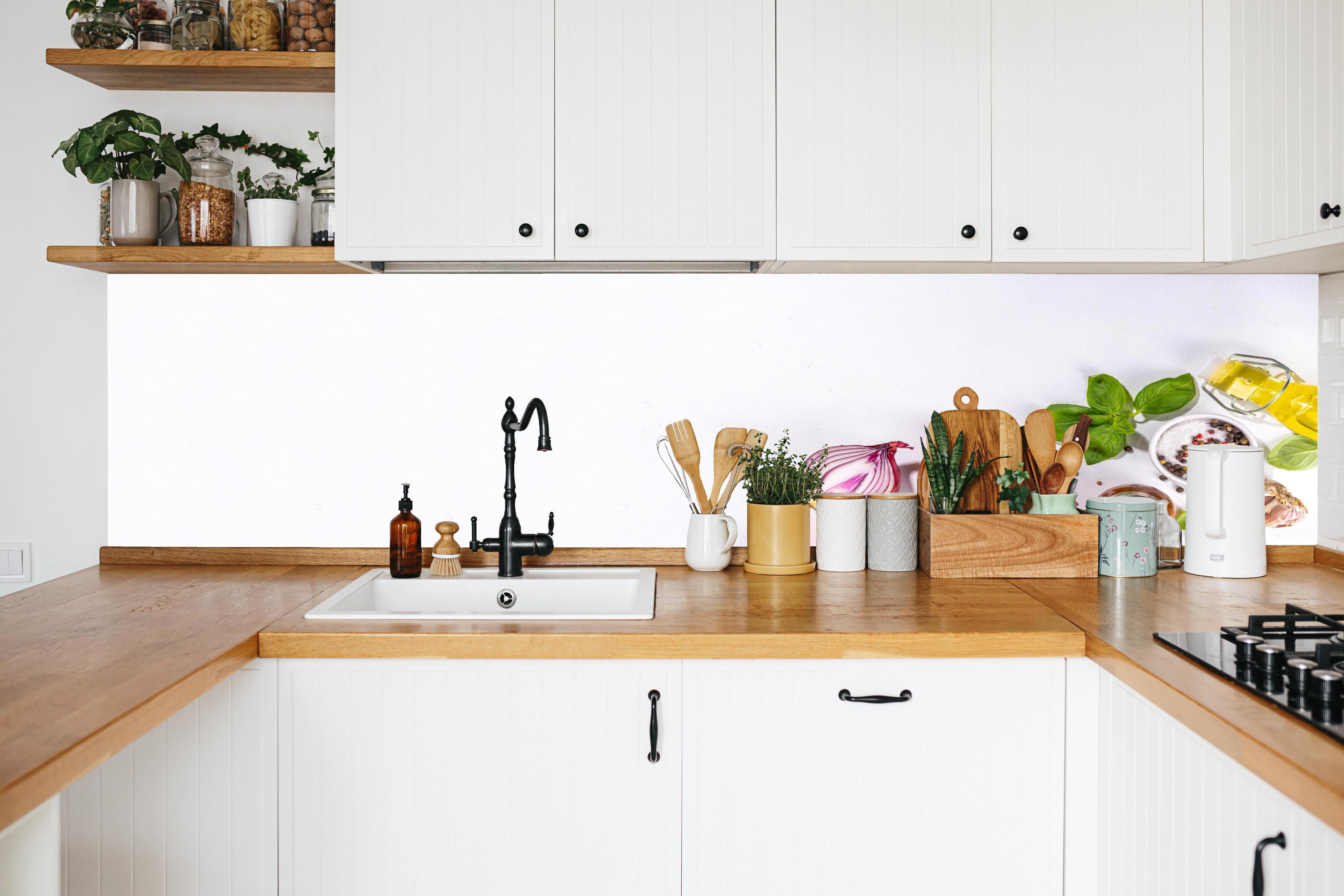 Küche - Weißes Tomaten-Kräuter Stillleben in weißer Küche hinter Gewürzen und Kochlöffeln aus Holz