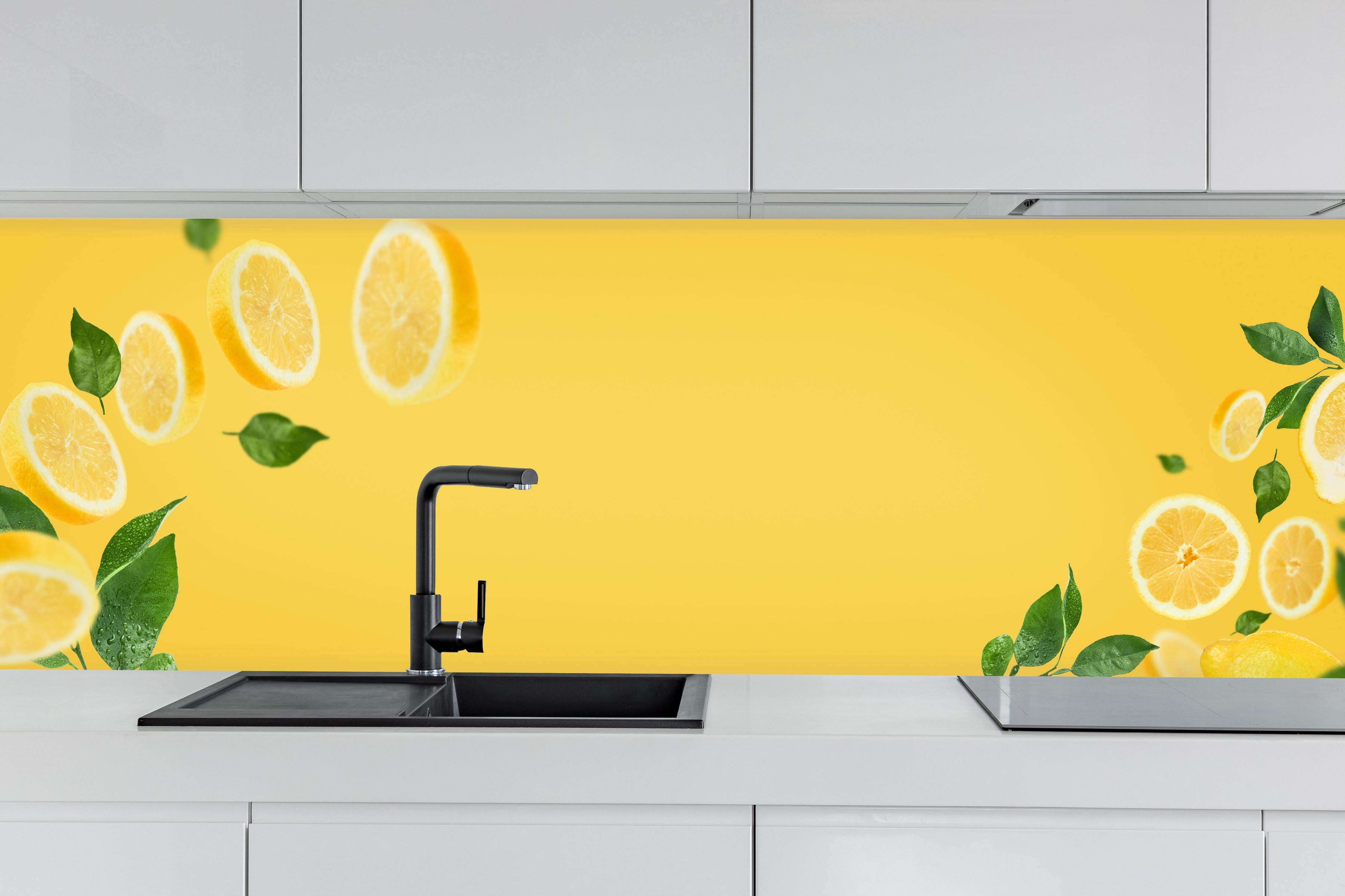 Küche - Zitronen Limetten Gelb-Grün hinter weißen Hochglanz-Küchenregalen und schwarzem Wasserhahn