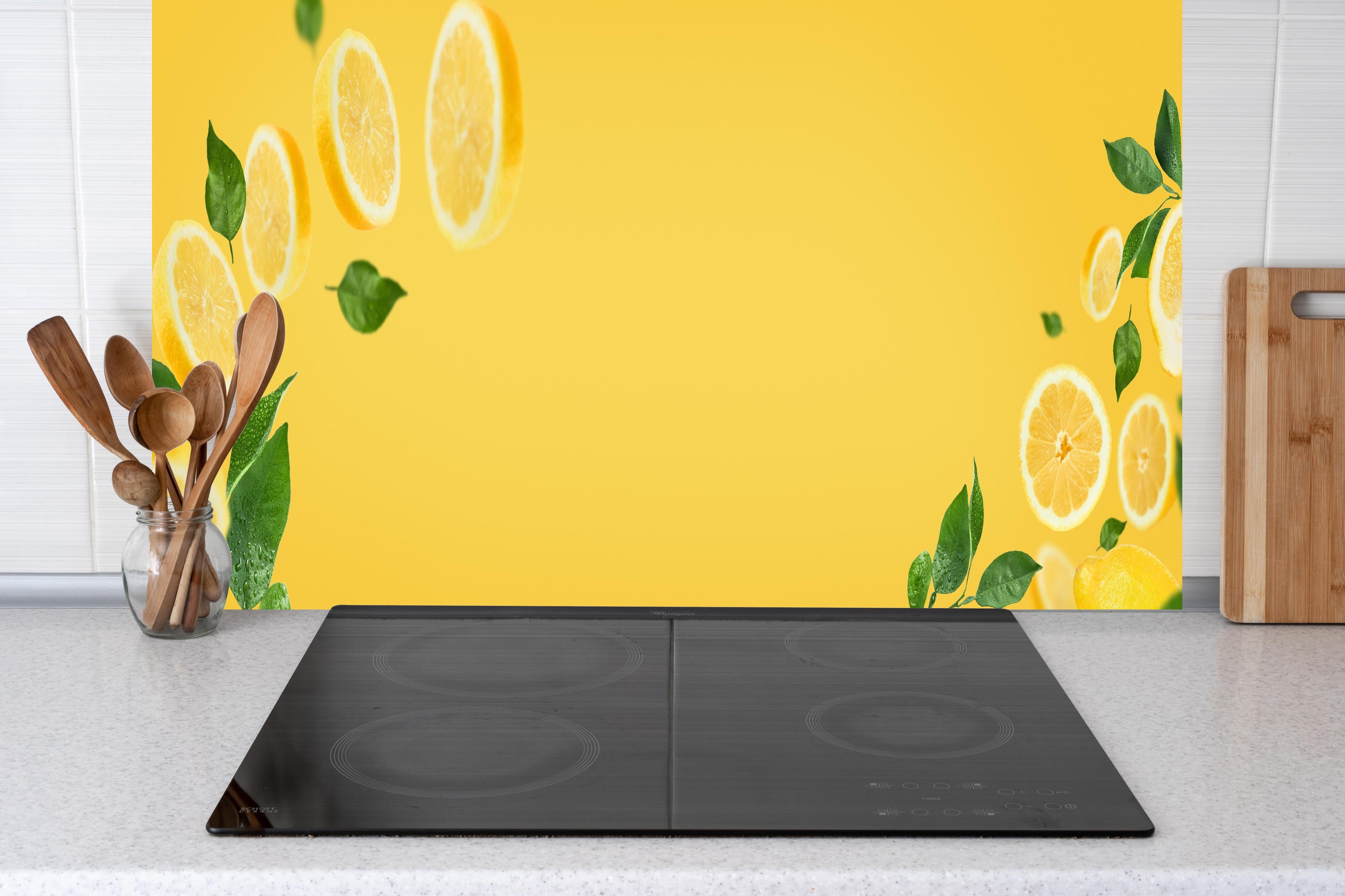 Küche - Zitronen Limetten Gelb-Grün hinter Cerankochfeld und Holz-Kochutensilien