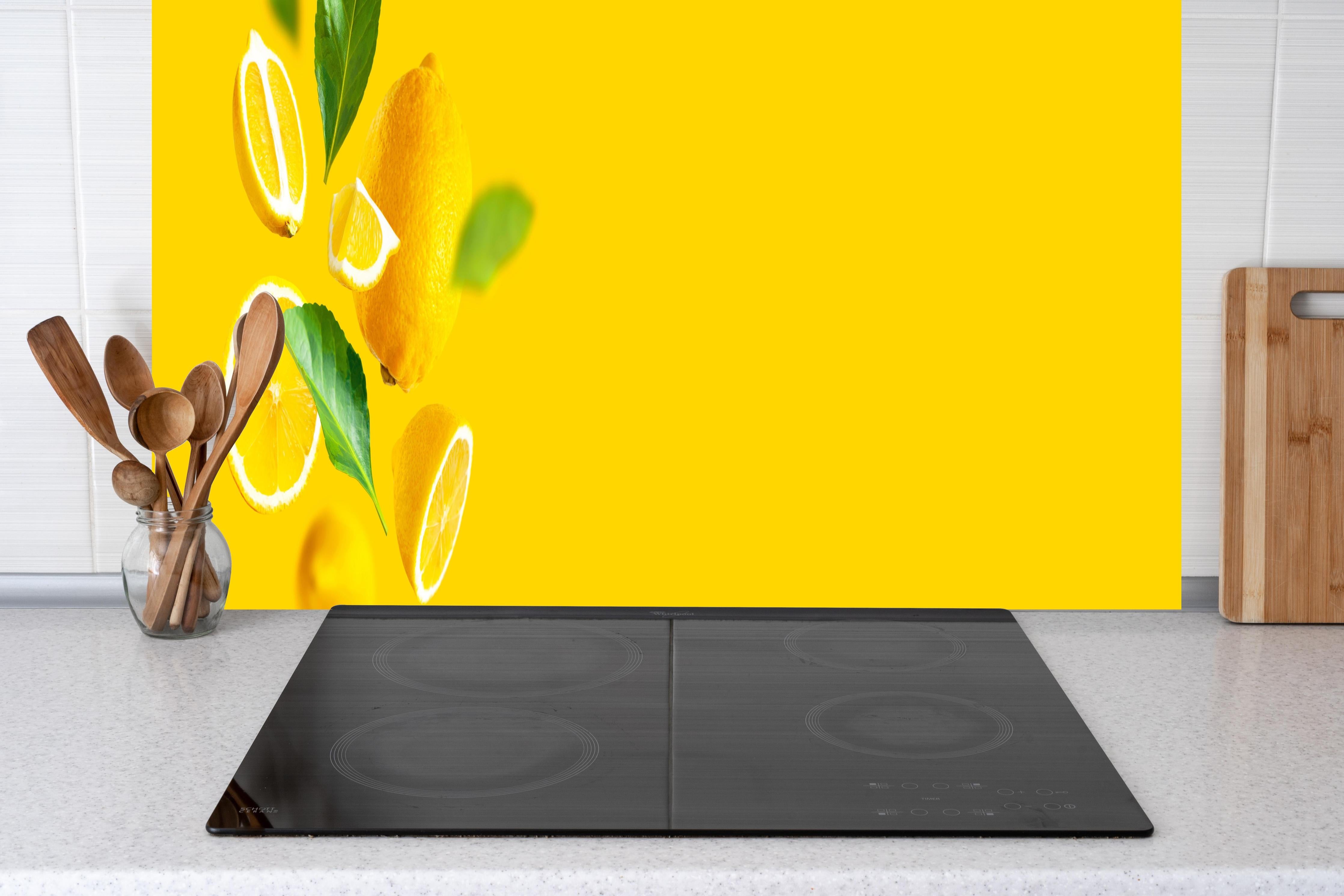 Küche - Zitronen Limetten Gelber Hintergrund hinter Cerankochfeld und Holz-Kochutensilien