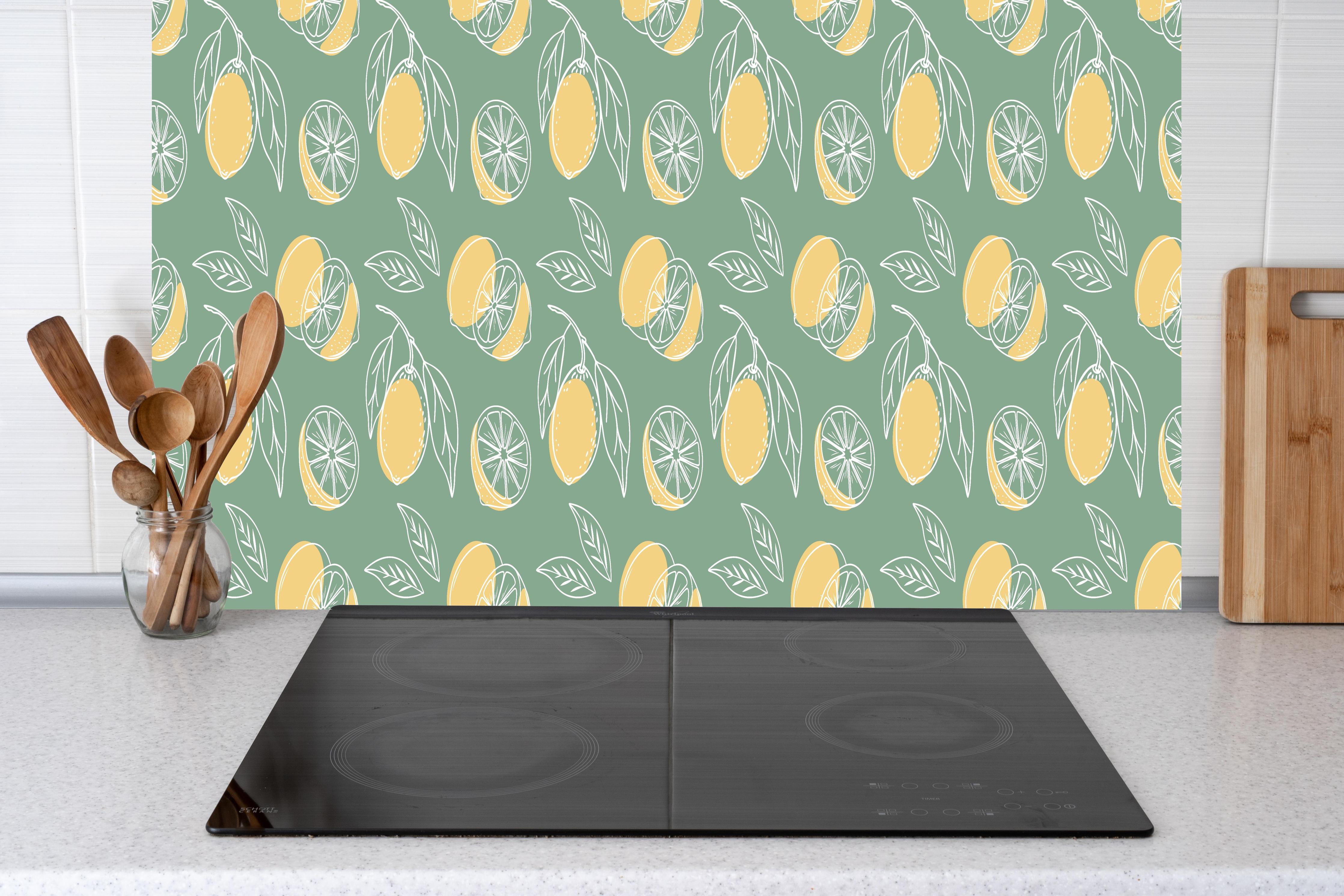 Küche - Zitronen-Muster Grün-Gelb hinter Cerankochfeld und Holz-Kochutensilien