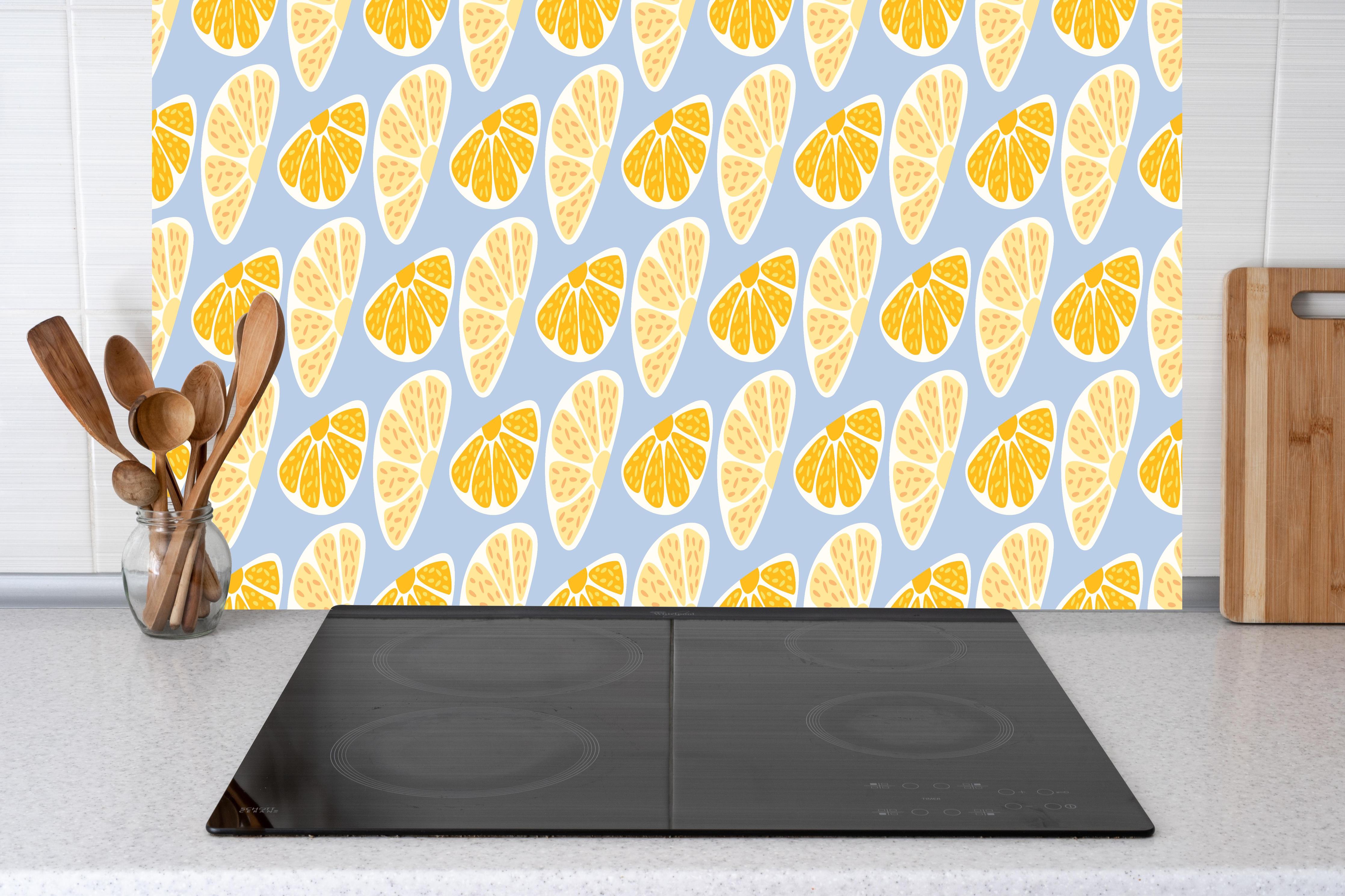 Küche - Zitrus-Orange-Muster hinter Cerankochfeld und Holz-Kochutensilien