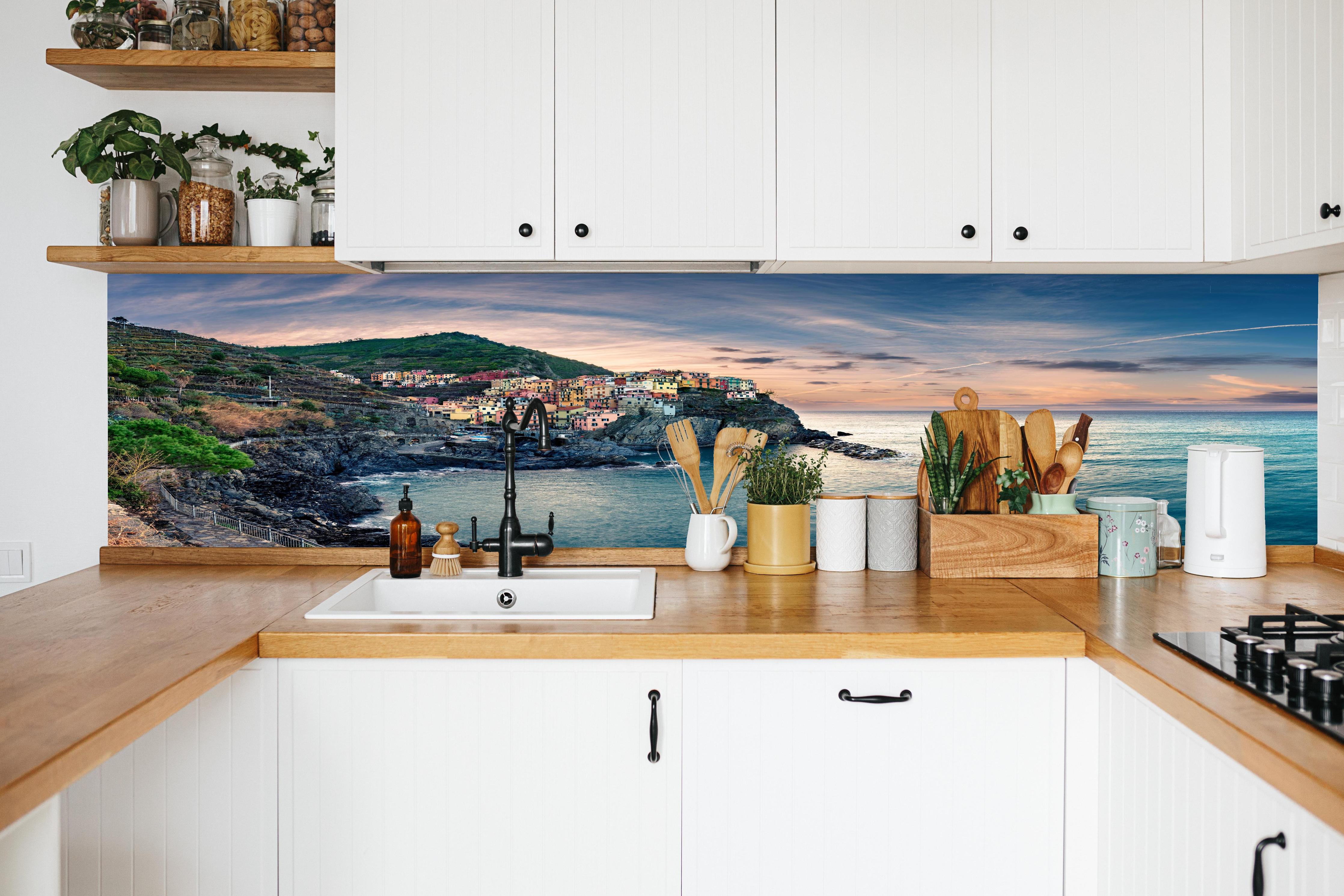 Küche - talienische Küste im Abendrot in weißer Küche hinter Gewürzen und Kochlöffeln aus Holz
