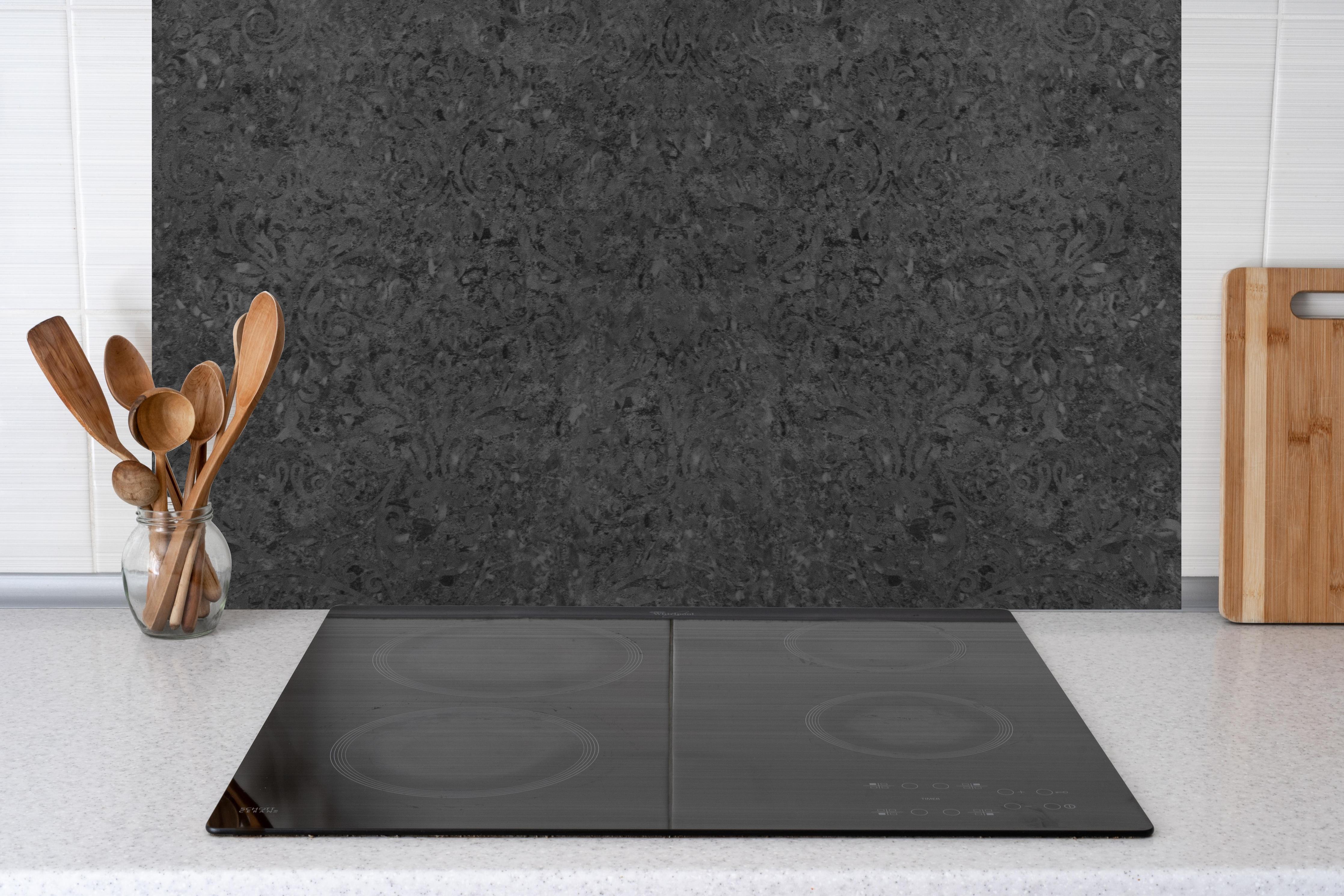 Küche - Scwarze Fliesen mit Muster hinter Cerankochfeld und Holz-Kochutensilien