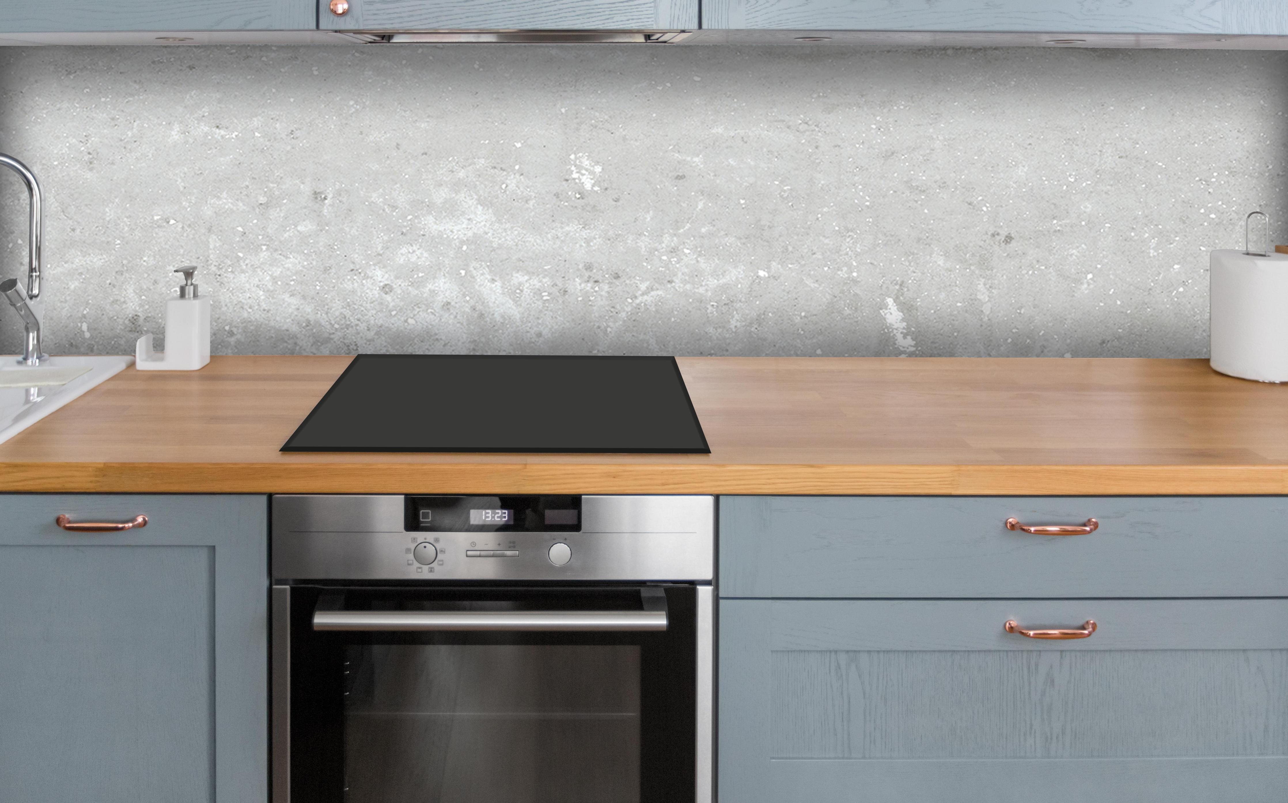 Küche - Antik weiß-gräuliche Betonwand über polierter Holzarbeitsplatte mit Cerankochfeld