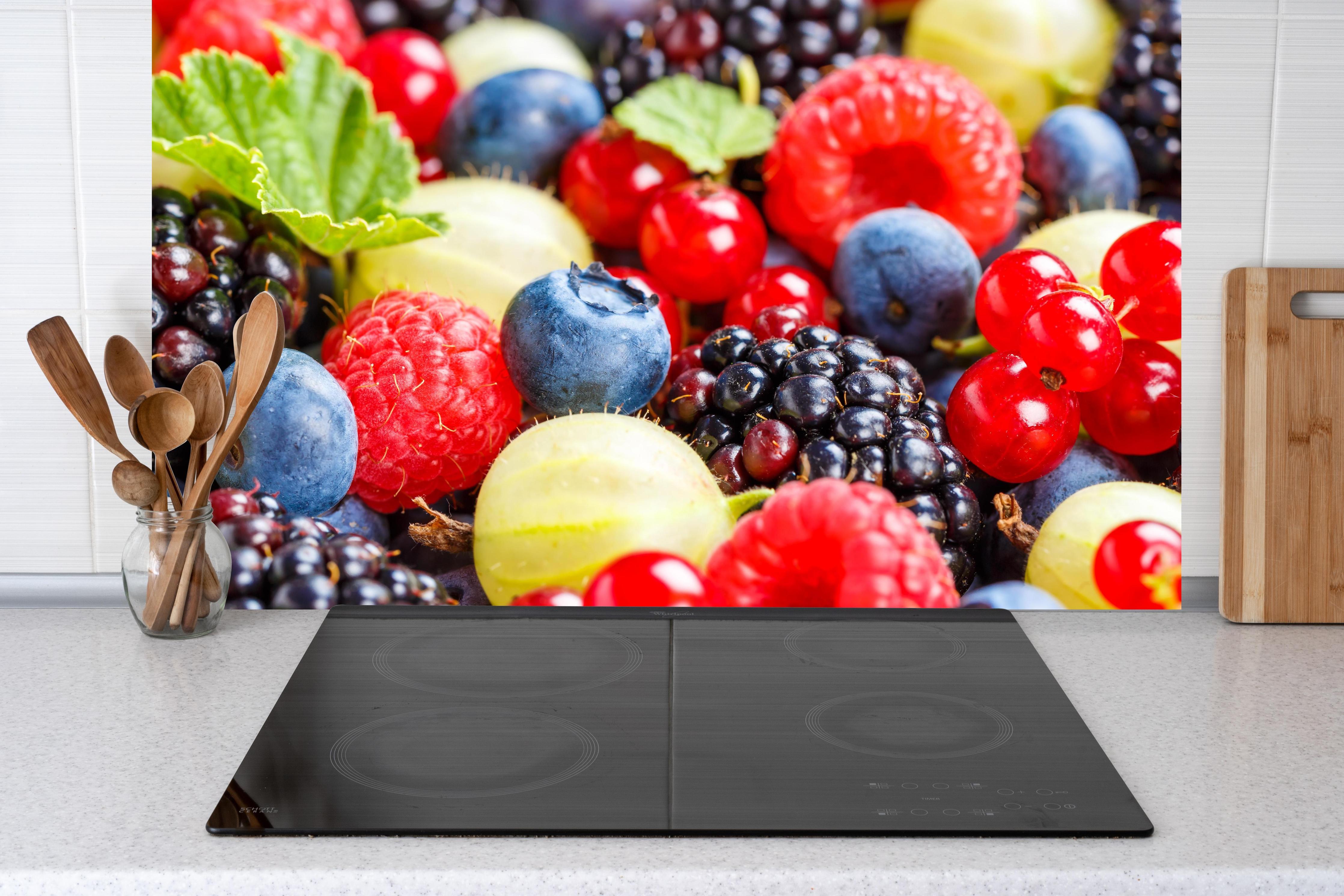 Küche - Beerenmischung hinter Cerankochfeld und Holz-Kochutensilien