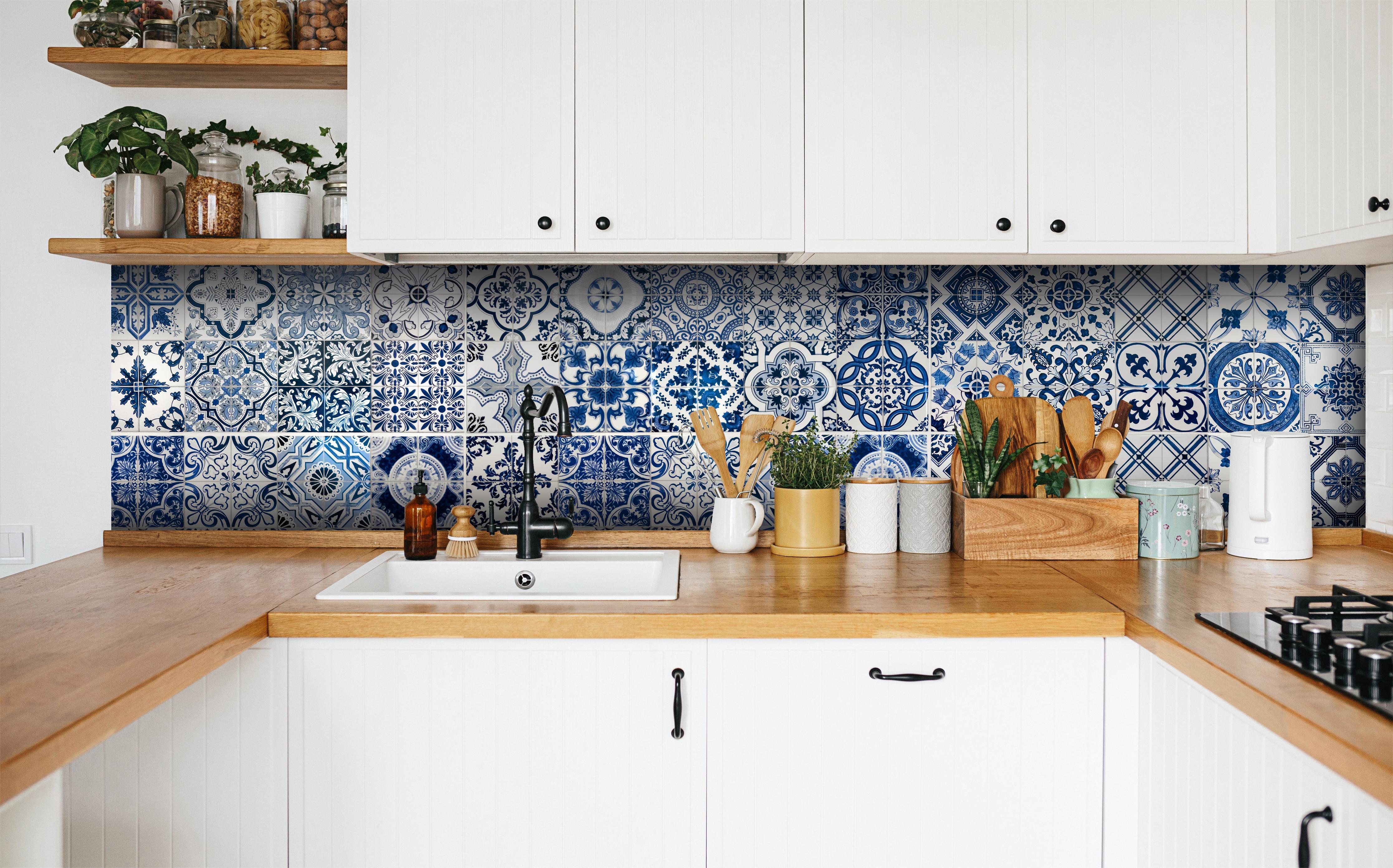 Küche - Blaue portugiesische Azulejo-Fliesen in weißer Küche hinter Gewürzen und Kochlöffeln aus Holz
