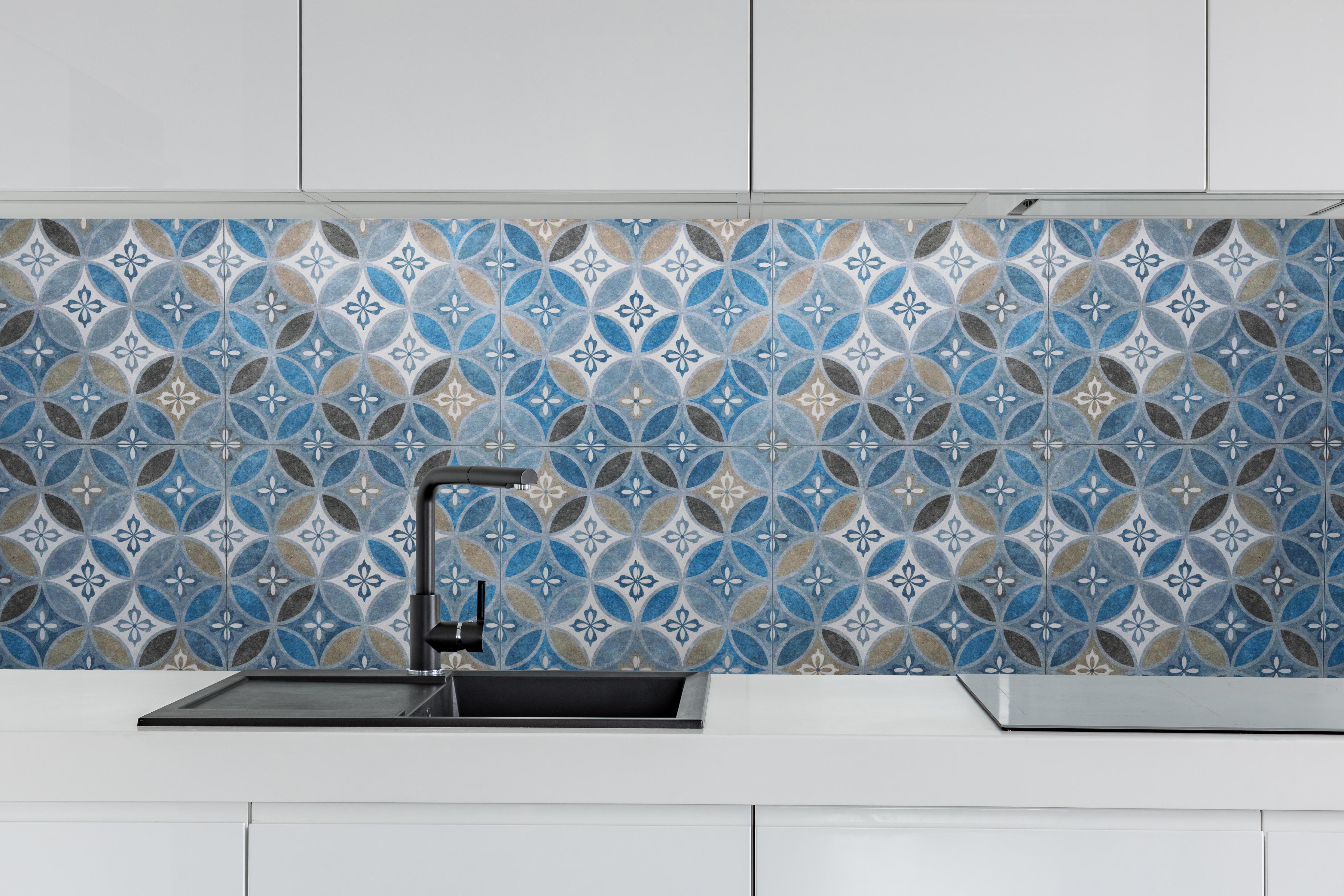 Küche - Blaues Vintage Mosaik hinter weißen Hochglanz-Küchenregalen und schwarzem Wasserhahn