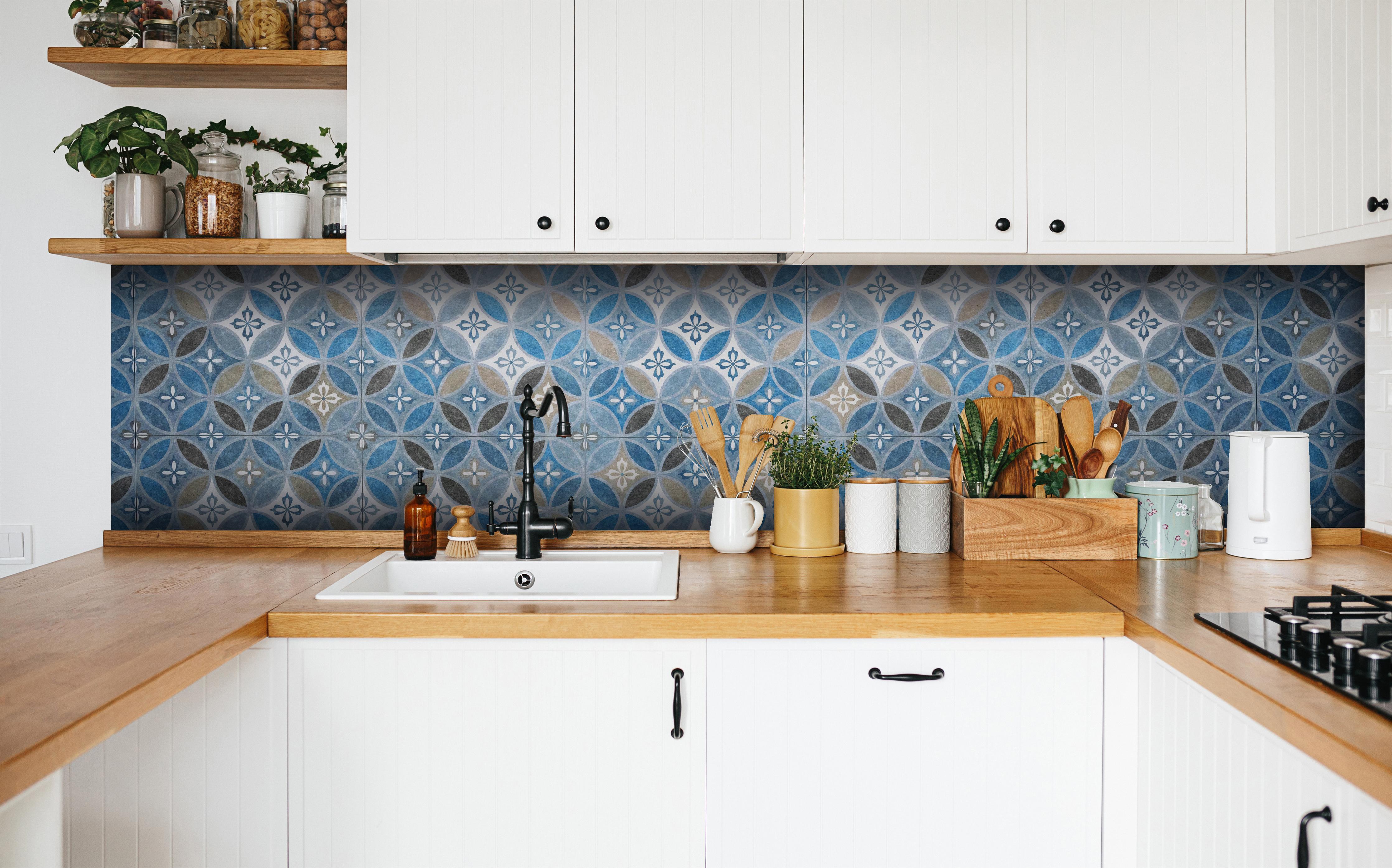 Küche - Blaues Vintage Mosaik in weißer Küche hinter Gewürzen und Kochlöffeln aus Holz