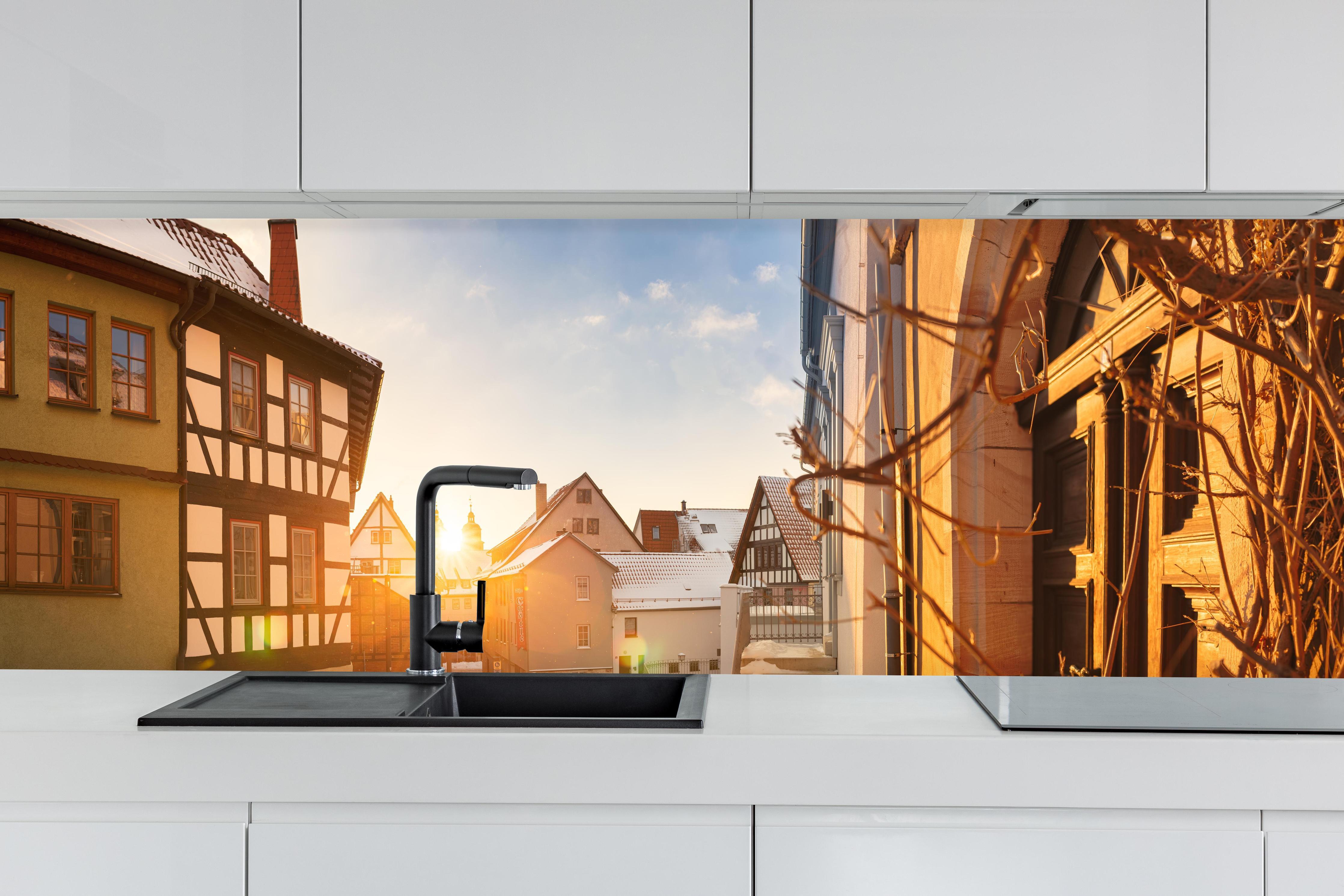 Küche - Blick auf Schmalkalden im Winter hinter weißen Hochglanz-Küchenregalen und schwarzem Wasserhahn