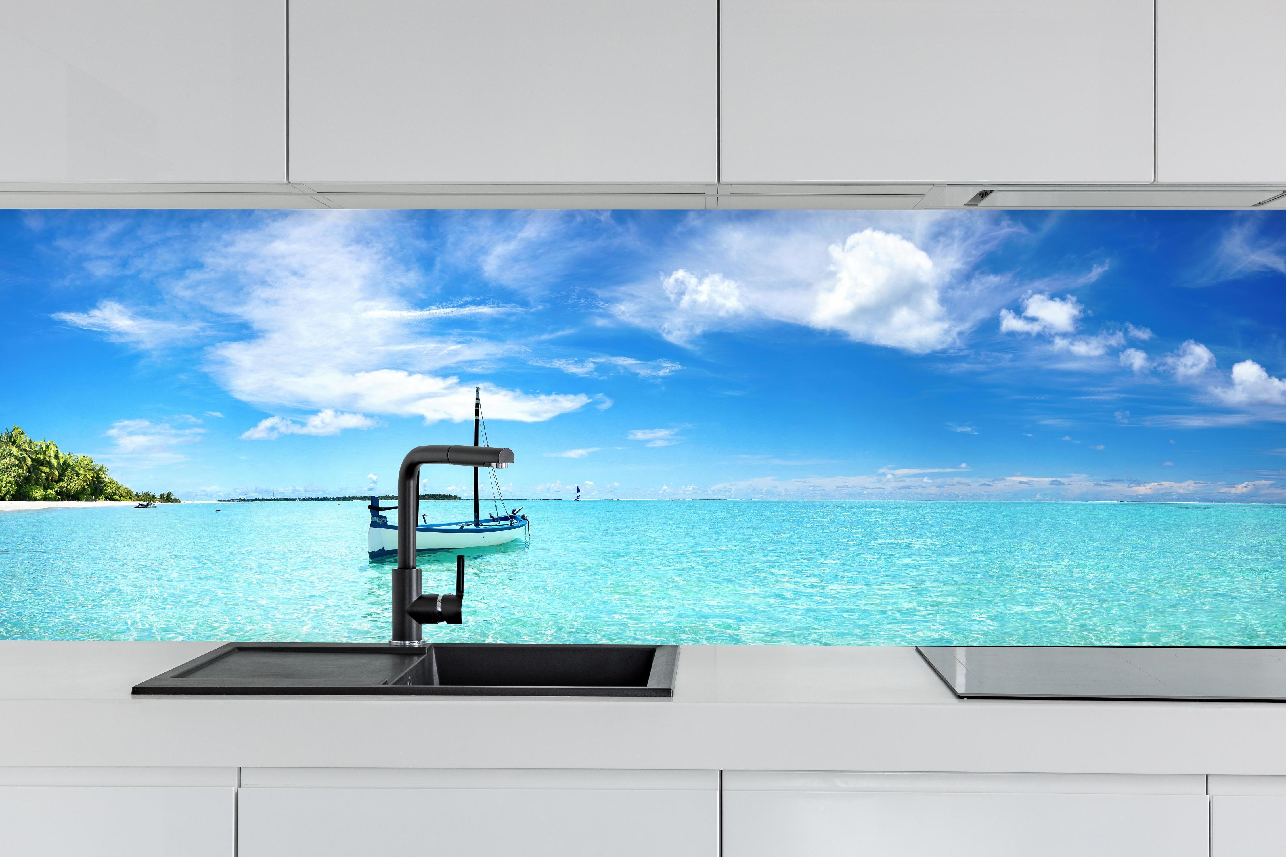 Küche - Boot im türkisfarbenen Meerwasser hinter weißen Hochglanz-Küchenregalen und schwarzem Wasserhahn