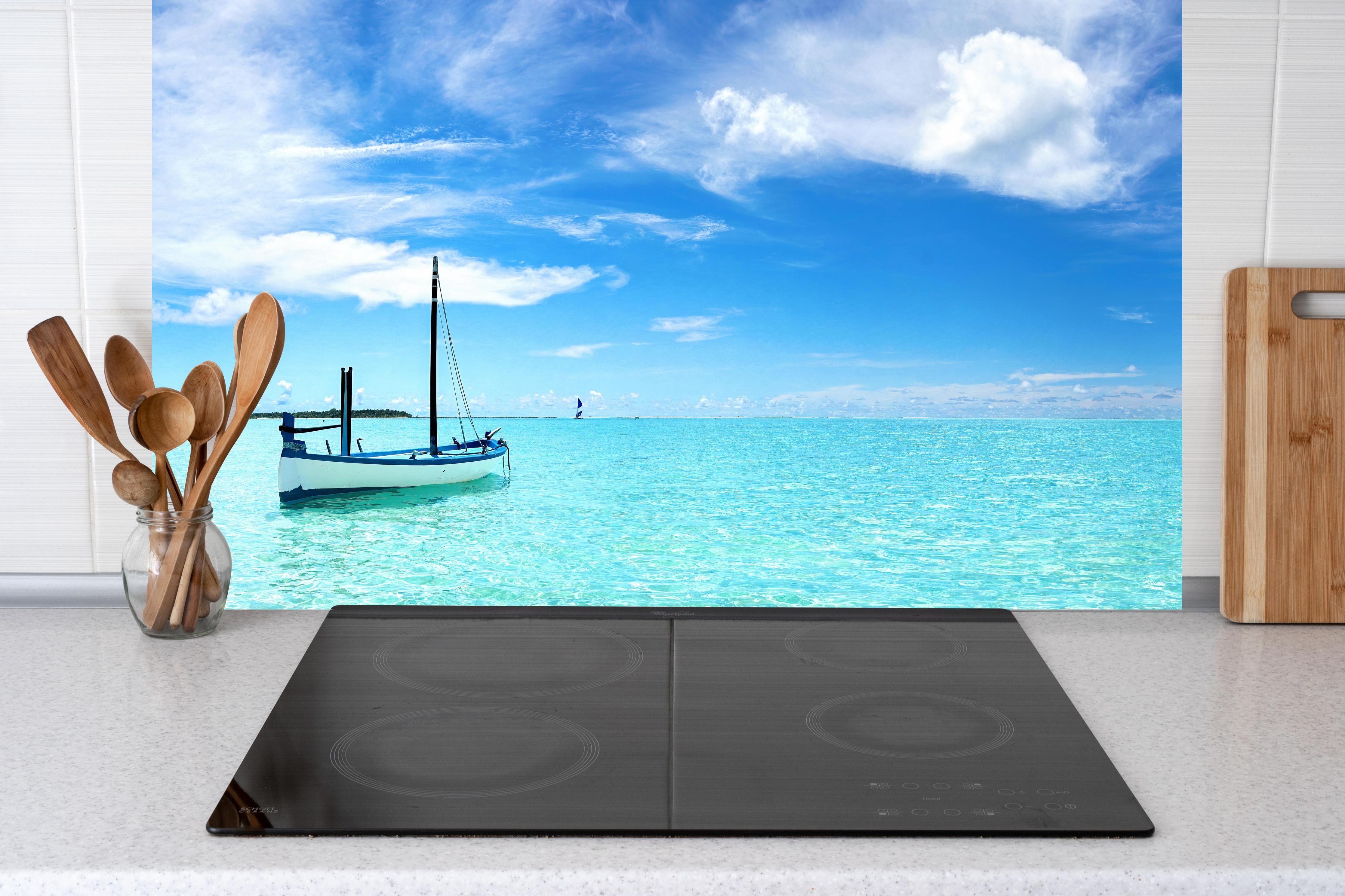 Küche - Boot im türkisfarbenen Meerwasser hinter Cerankochfeld und Holz-Kochutensilien