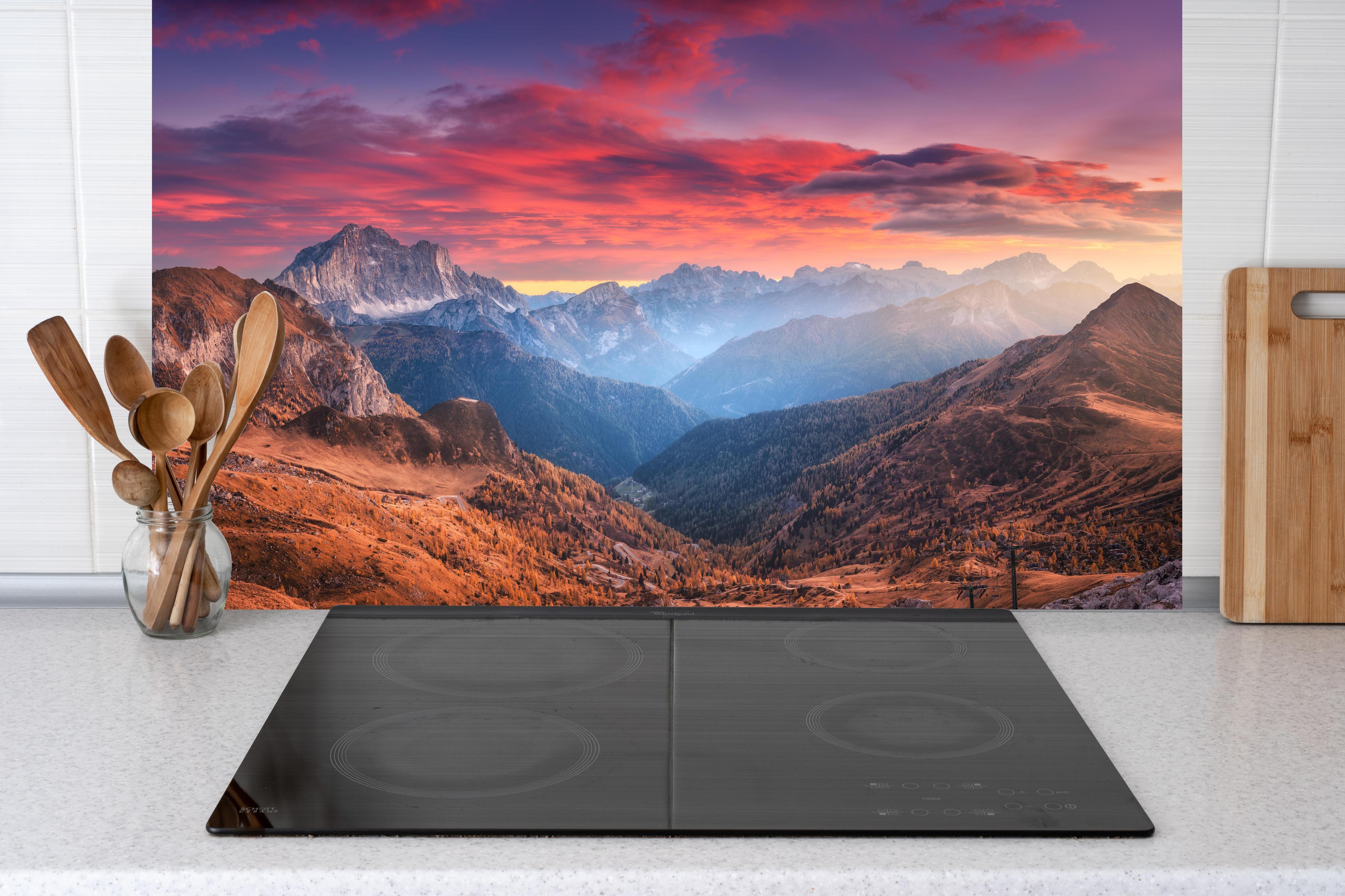 Küche - Bunt roter Himmel hinter Cerankochfeld und Holz-Kochutensilien