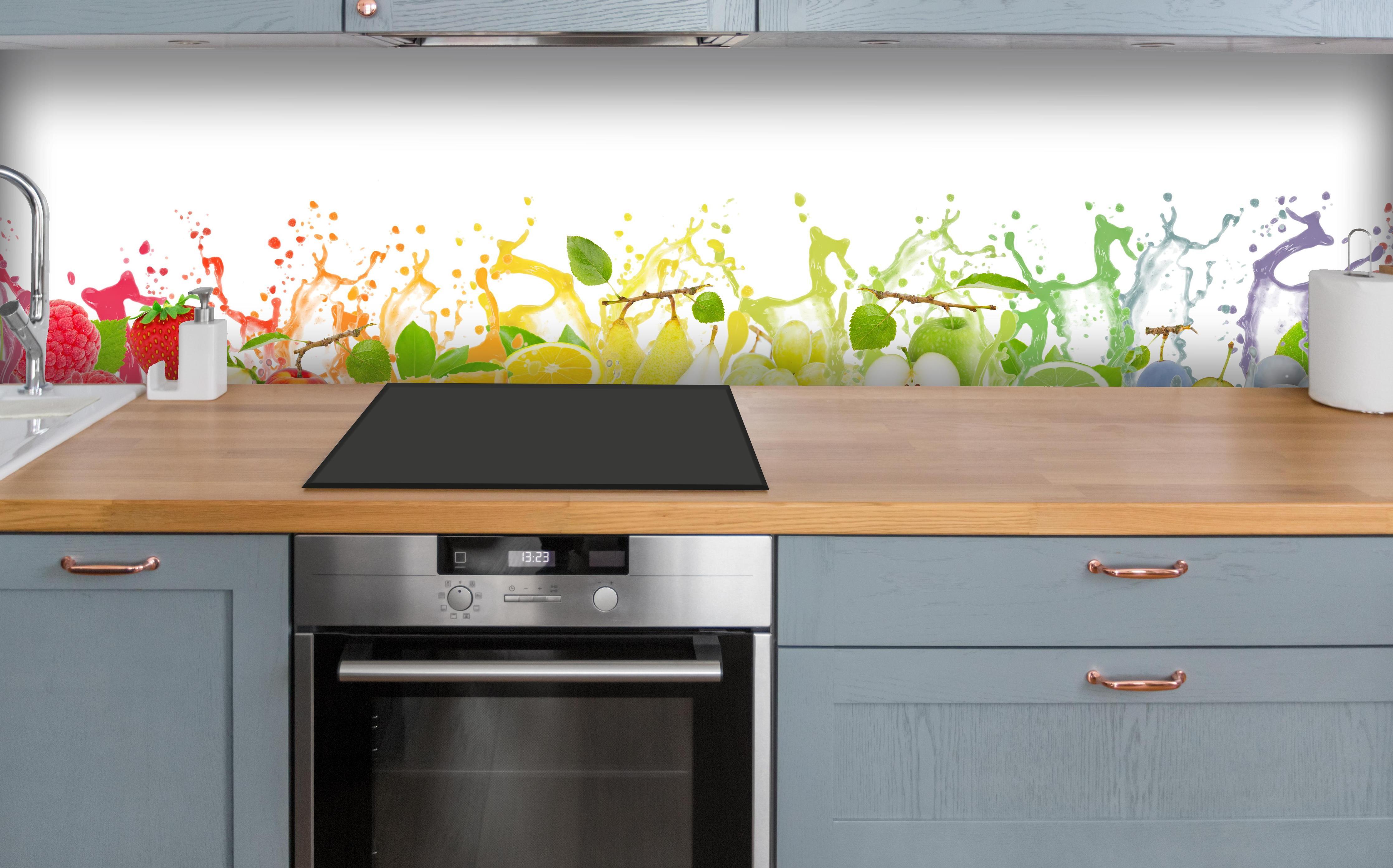 Küche - Bunte spritzige Früchte über polierter Holzarbeitsplatte mit Cerankochfeld