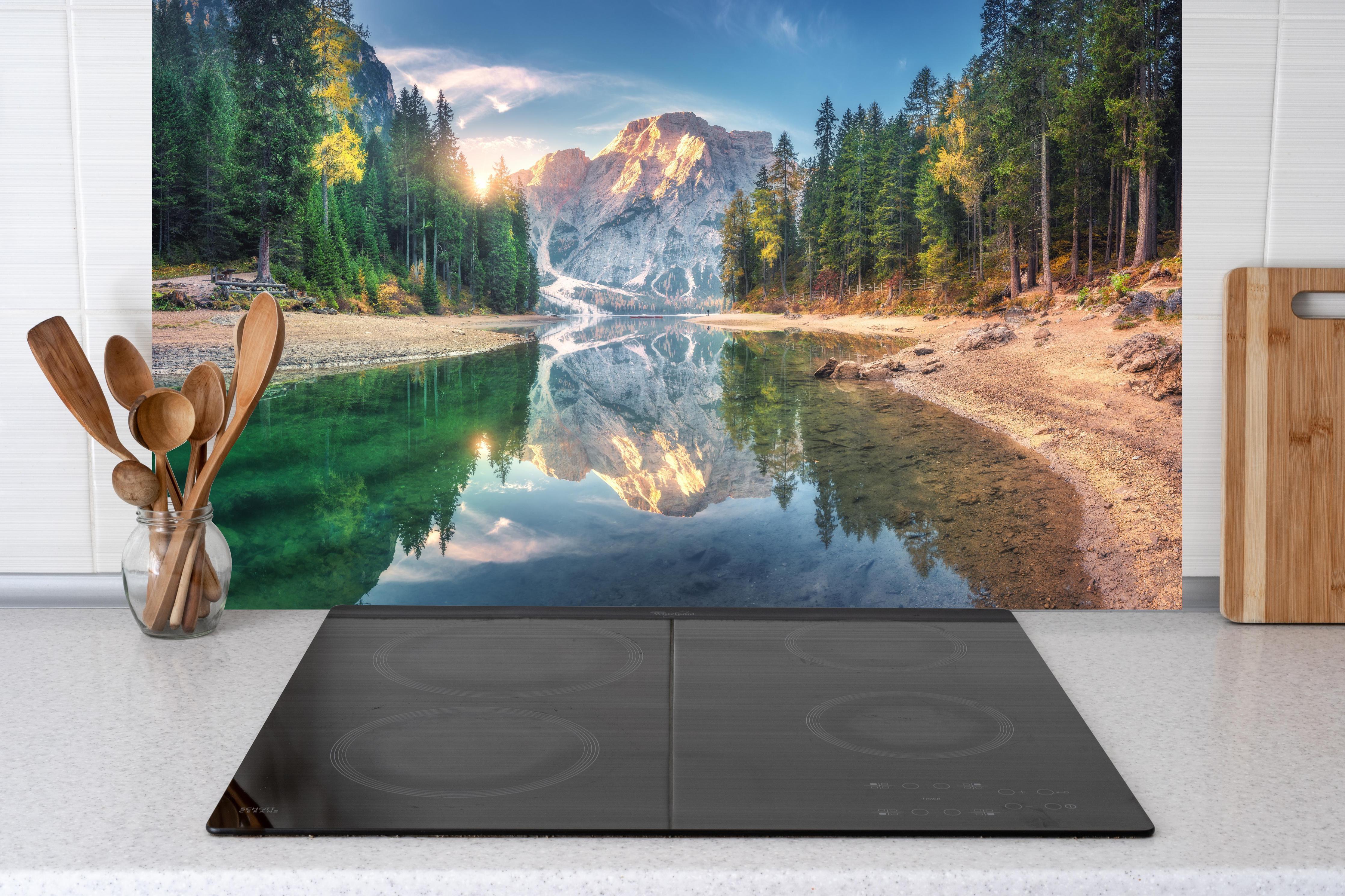 Küche - Erstaunlicher Pragser Wildsee bei Sonnenaufgang hinter Cerankochfeld und Holz-Kochutensilien