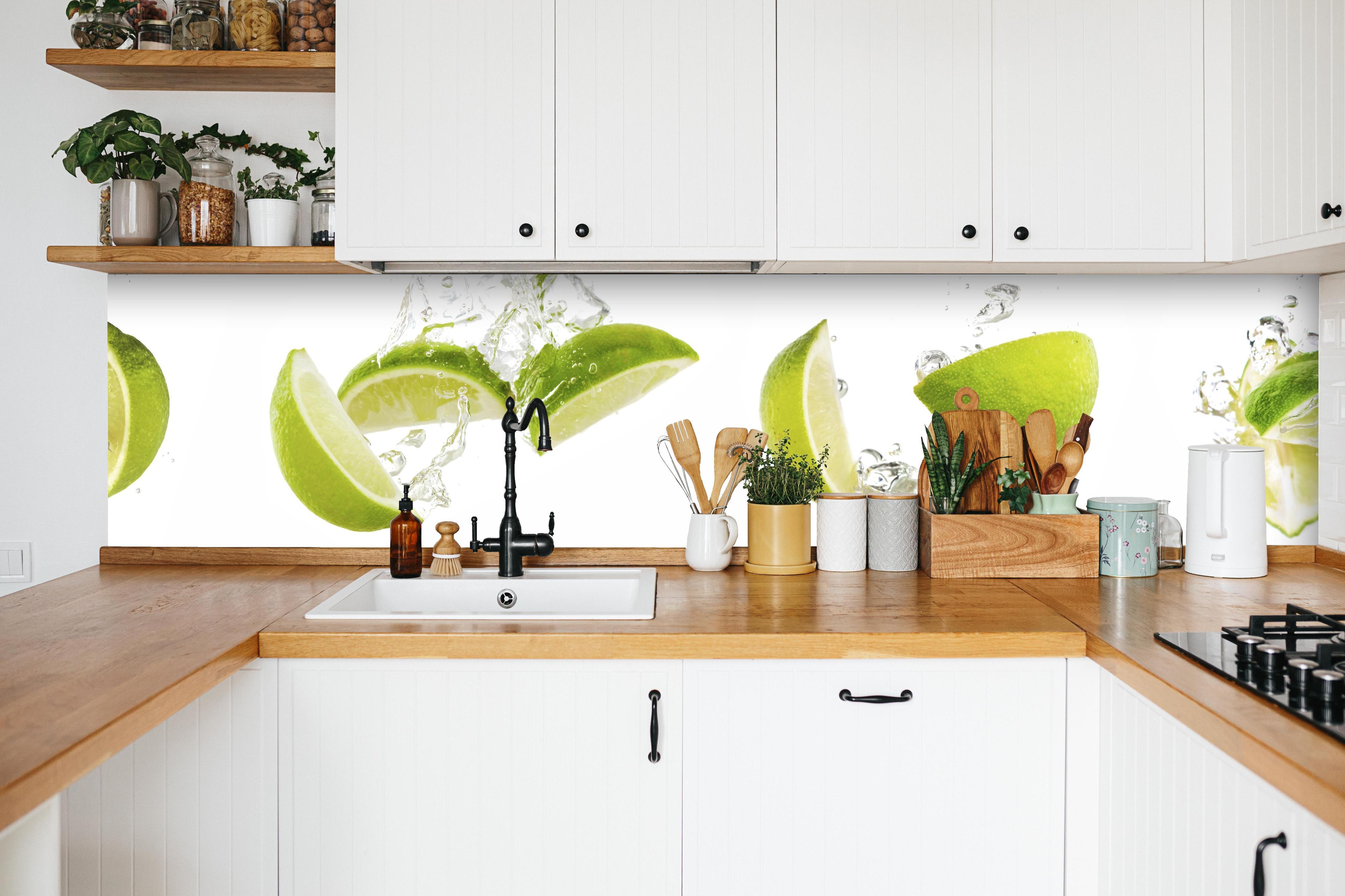 Küche - Frische Limette in Wasser in weißer Küche hinter Gewürzen und Kochlöffeln aus Holz