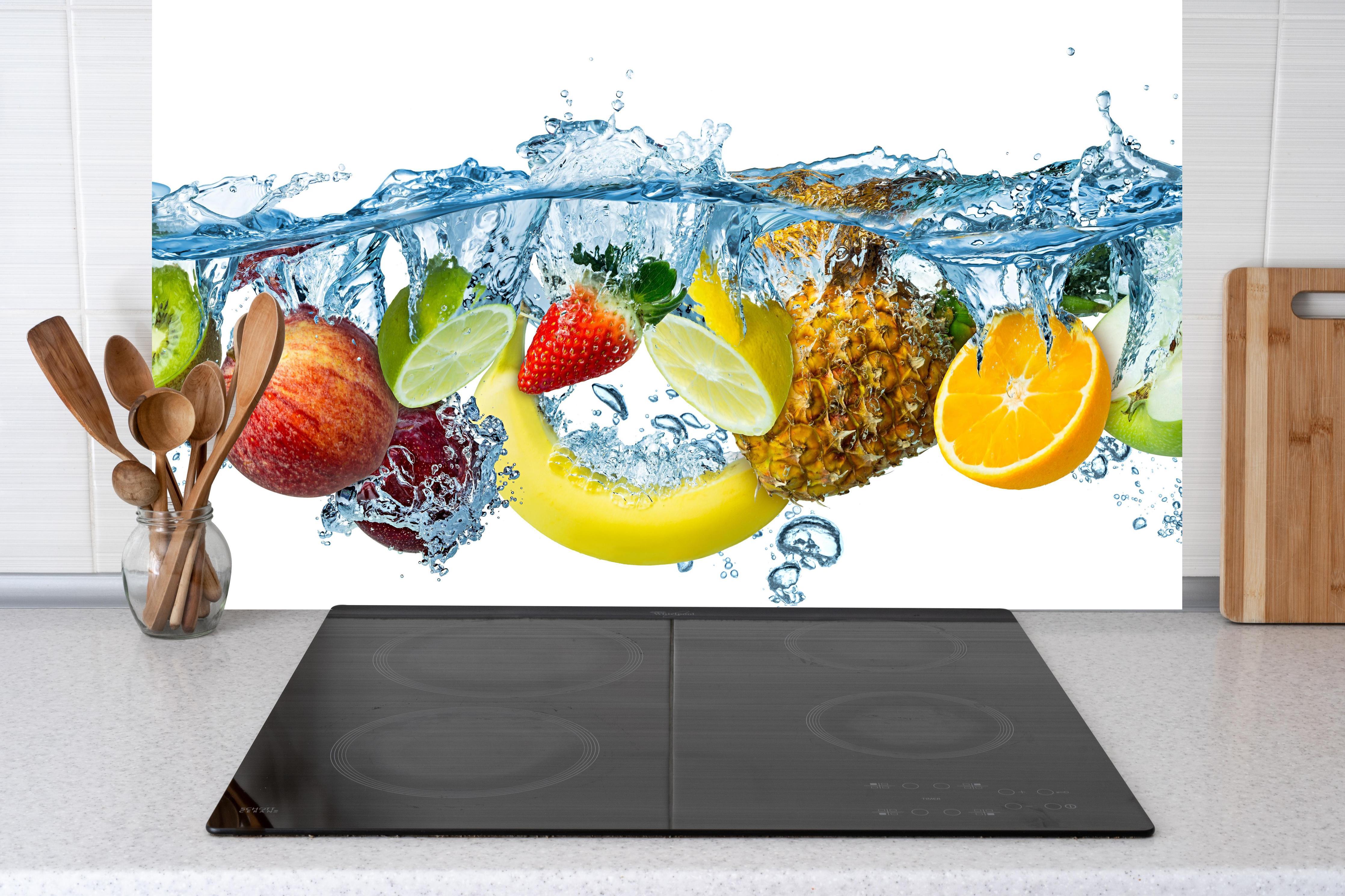 Küche - Frische Multifrüchte hinter Cerankochfeld und Holz-Kochutensilien