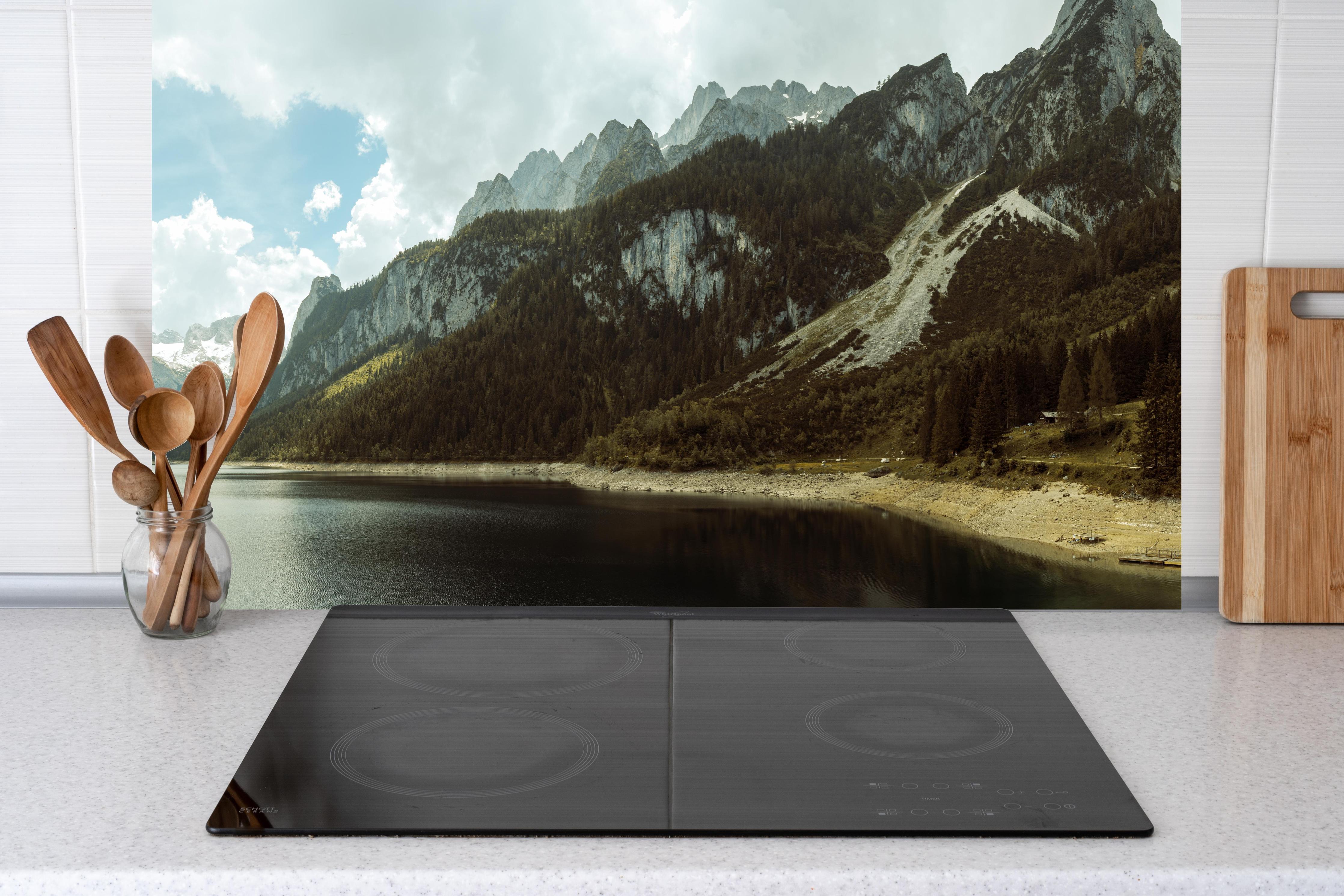 Küche - Gosausee Panorama hinter Cerankochfeld und Holz-Kochutensilien