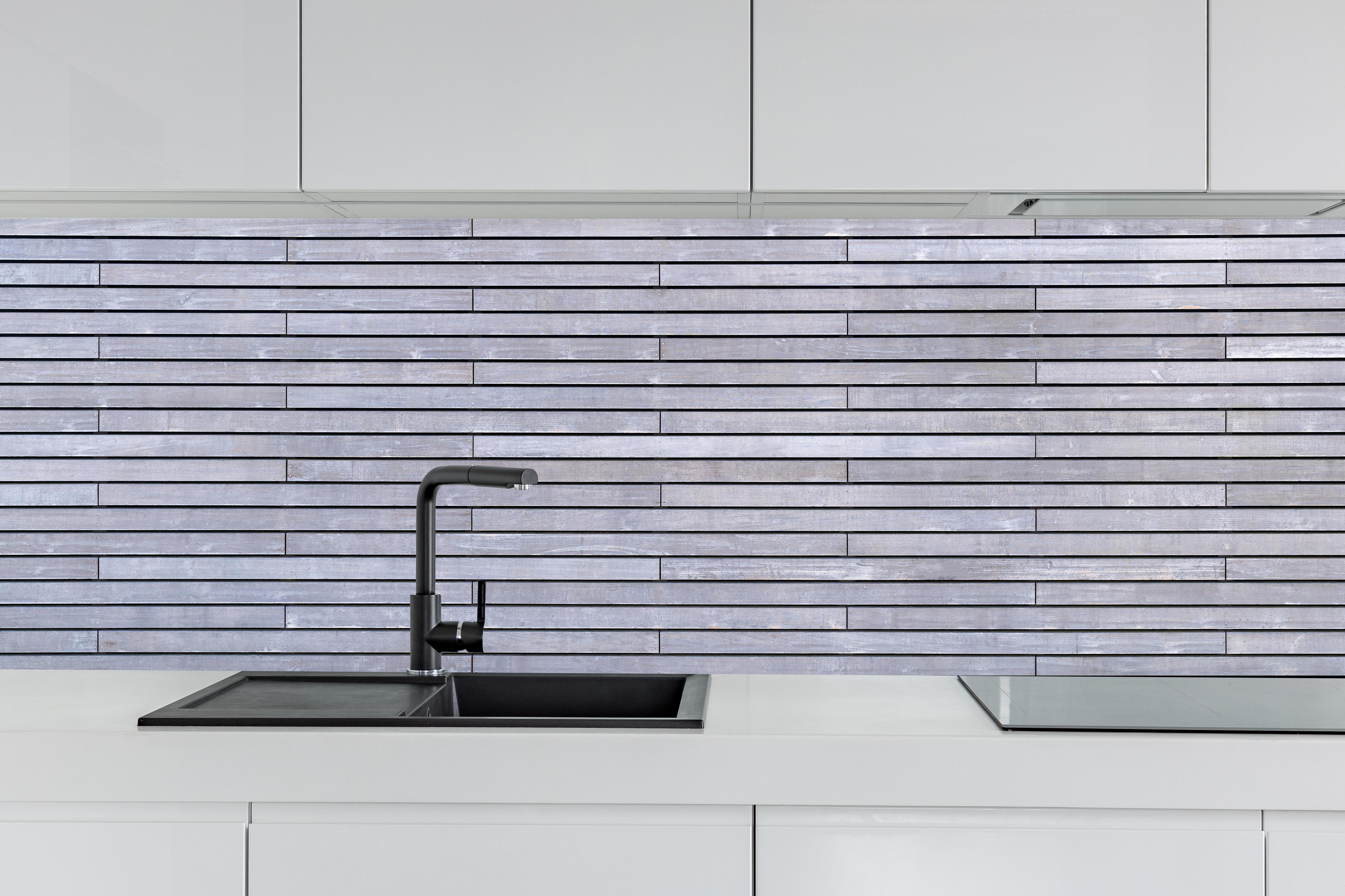 Küche - Graue Holzverkleidung hinter weißen Hochglanz-Küchenregalen und schwarzem Wasserhahn