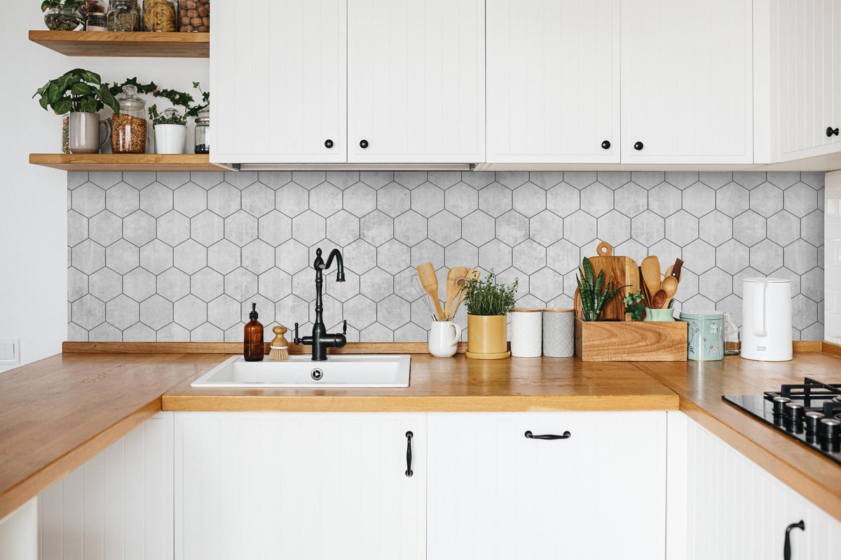 Küche - Graue sechseckige Mustern in weißer Küche hinter Gewürzen und Kochlöffeln aus Holz