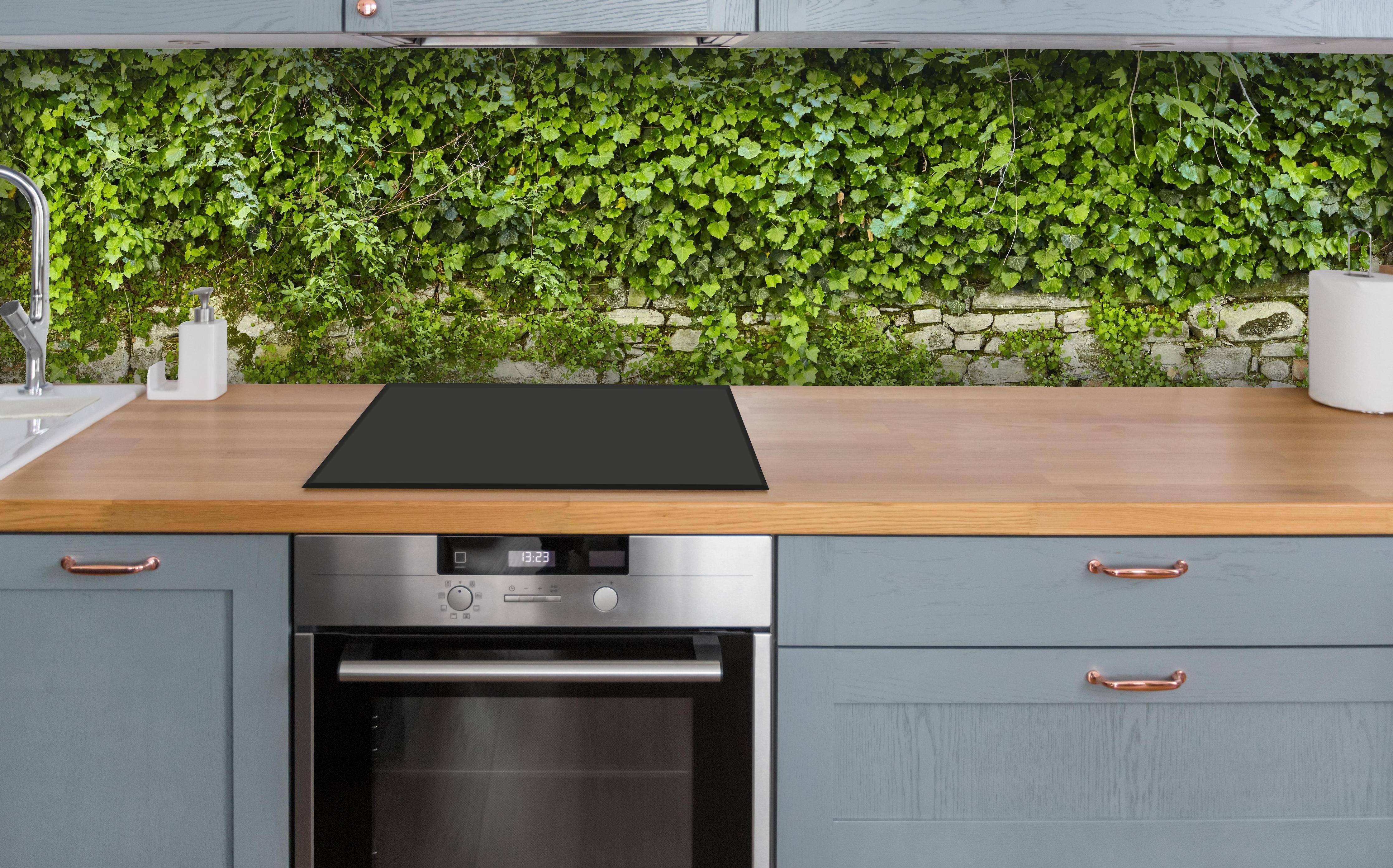Küche - Grün überwucherte Burgmauer über polierter Holzarbeitsplatte mit Cerankochfeld