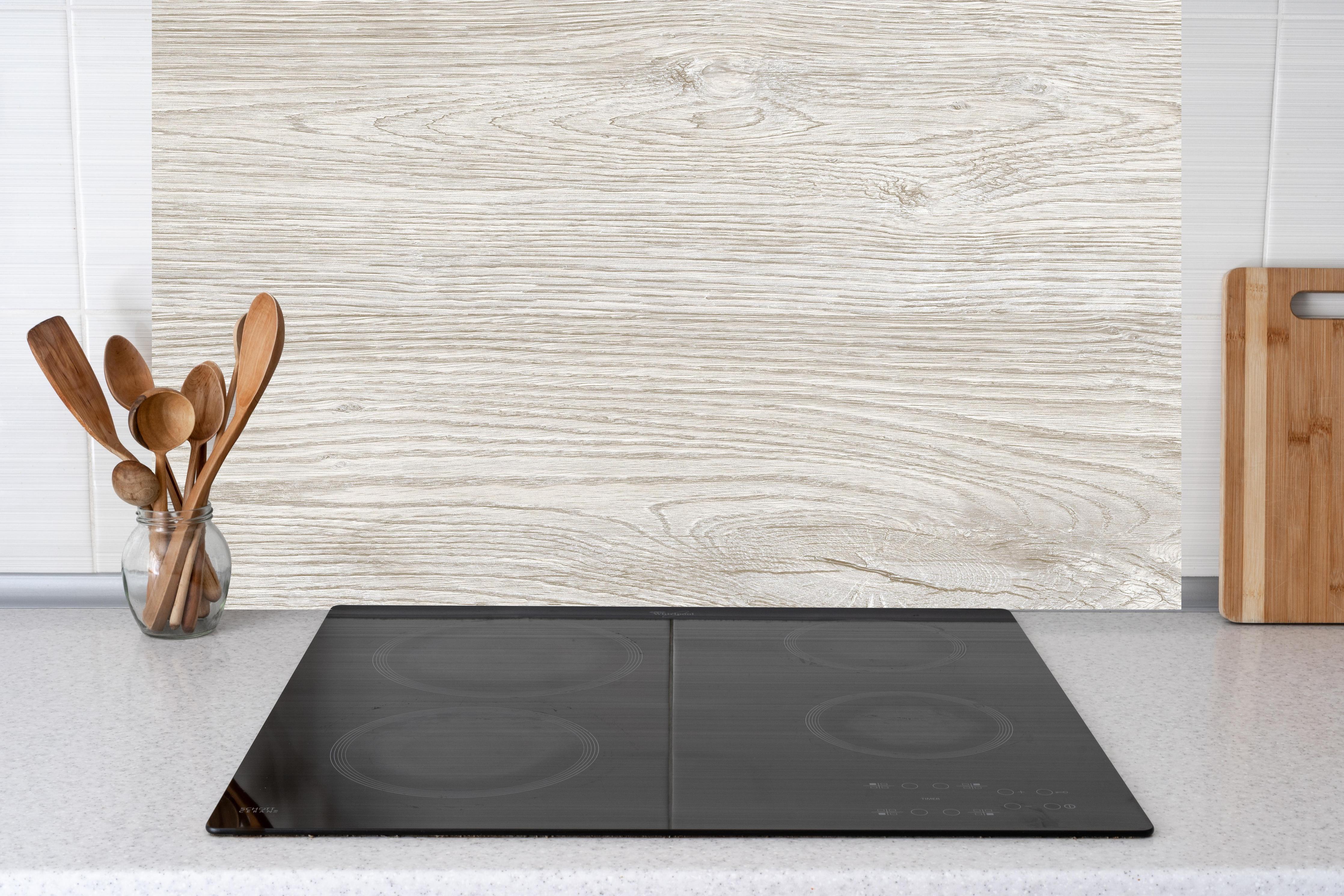 Küche - Helles Eichenholz hinter Cerankochfeld und Holz-Kochutensilien