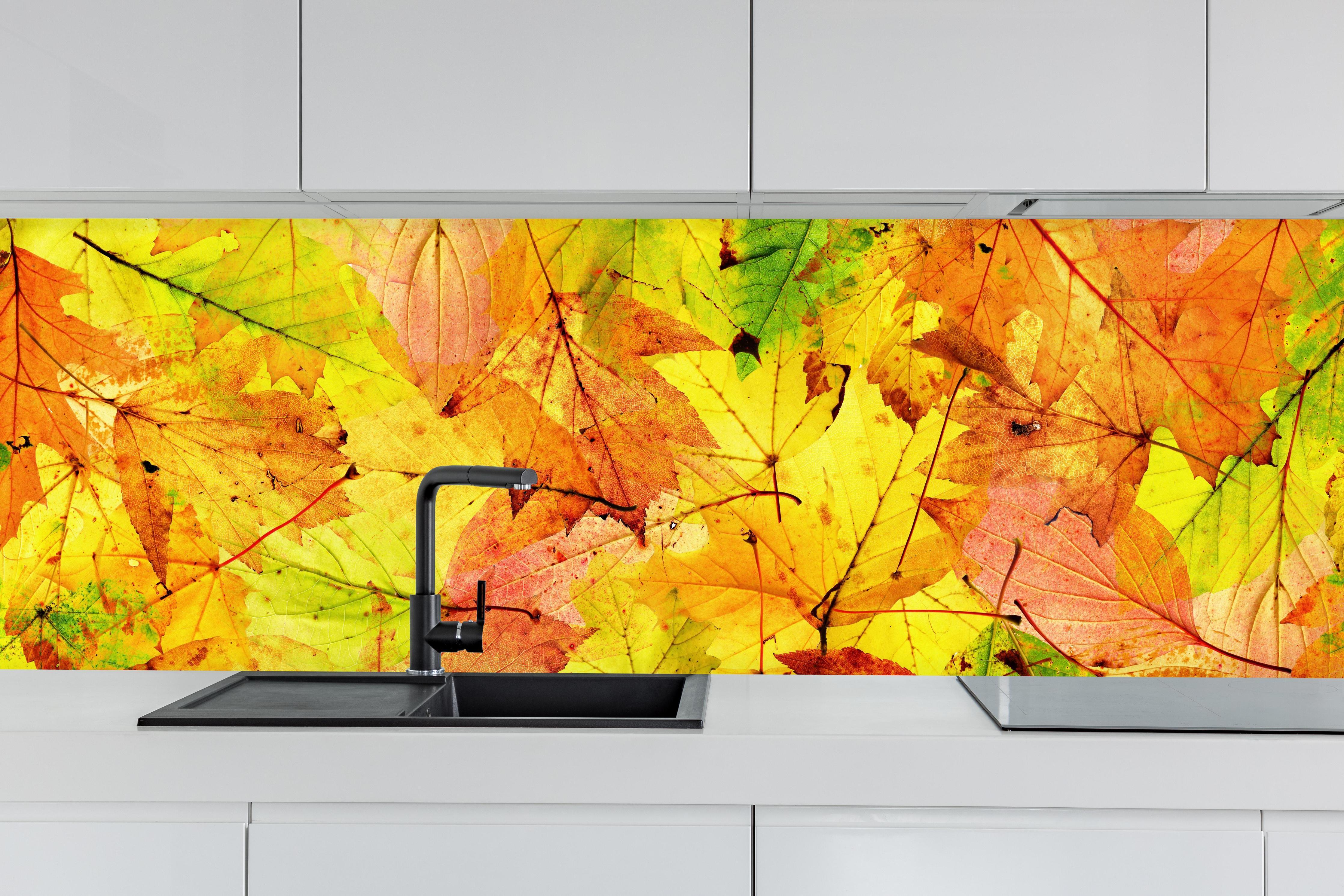 Küche - Herbstblätter Hintergrund hinter weißen Hochglanz-Küchenregalen und schwarzem Wasserhahn
