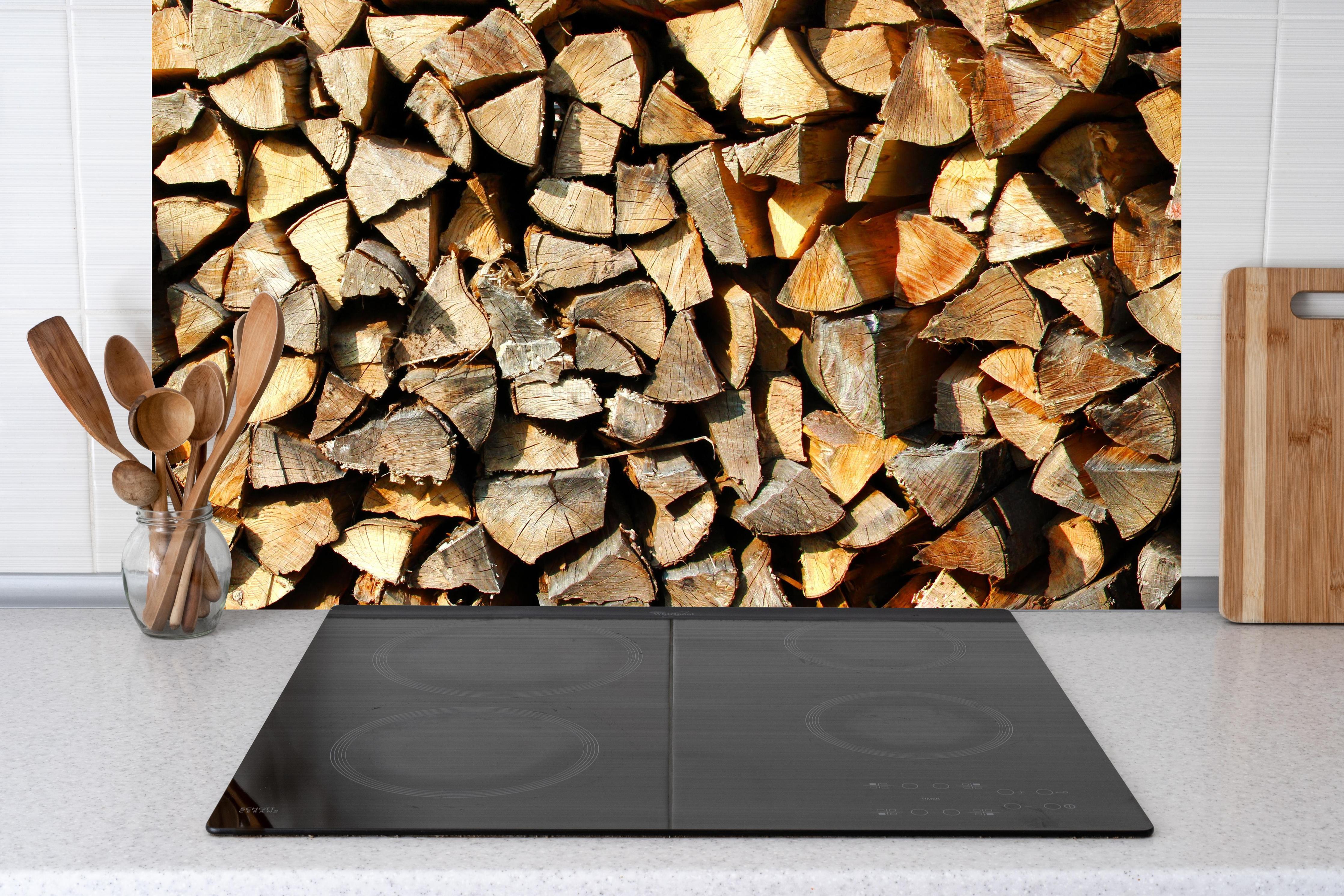 Küche - Holzstämme hinter Cerankochfeld und Holz-Kochutensilien