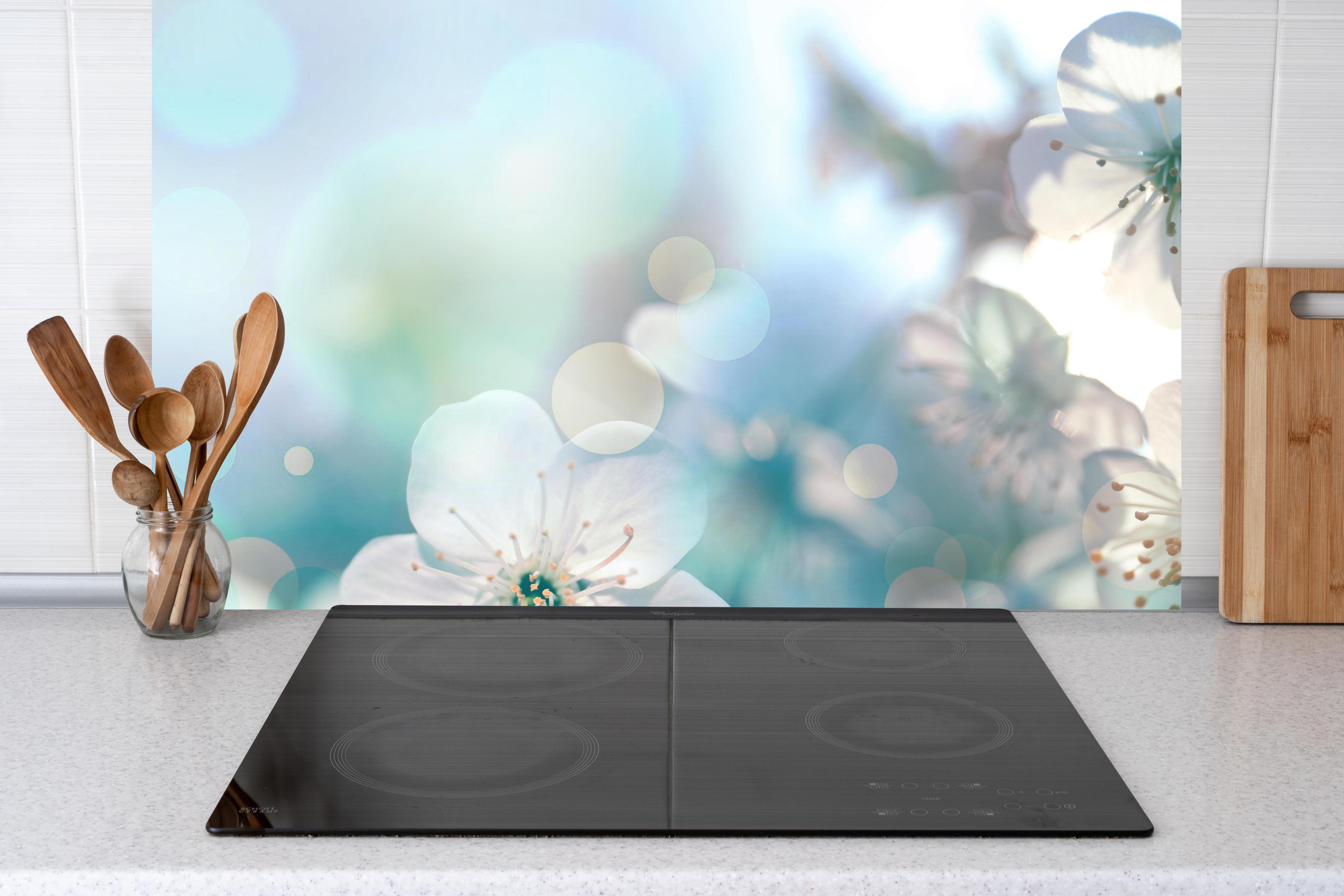 Küche - Kirchbaum Frühlings-Blüten hinter Cerankochfeld und Holz-Kochutensilien