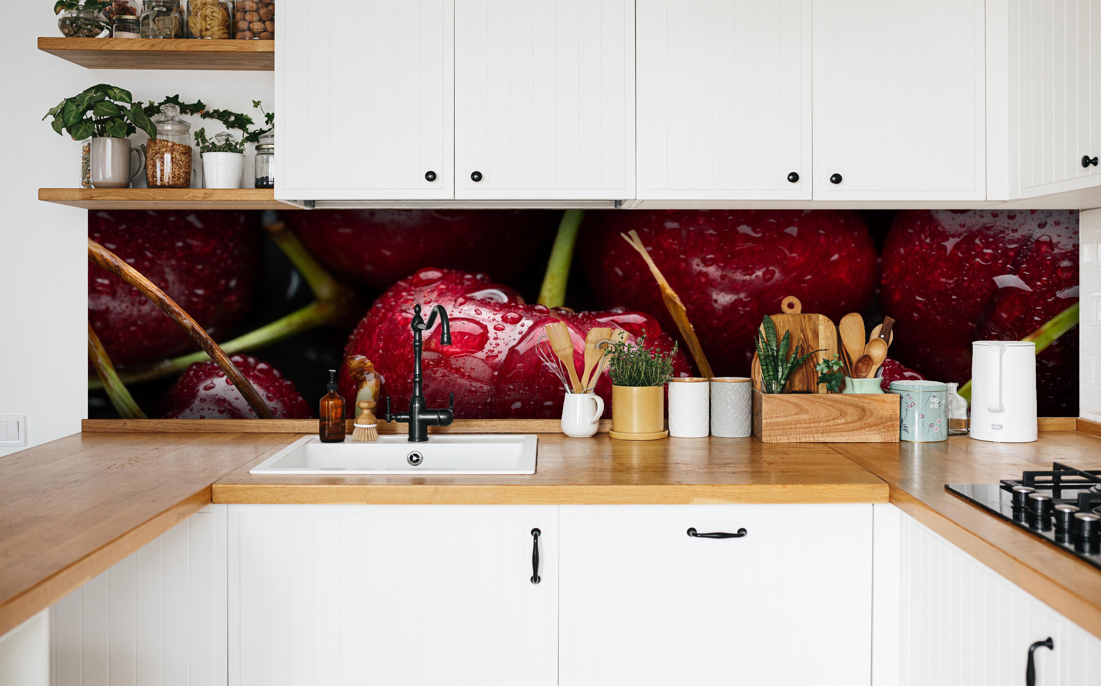 Küche - Kirschen mit Wasserperlen in weißer Küche hinter Gewürzen und Kochlöffeln aus Holz