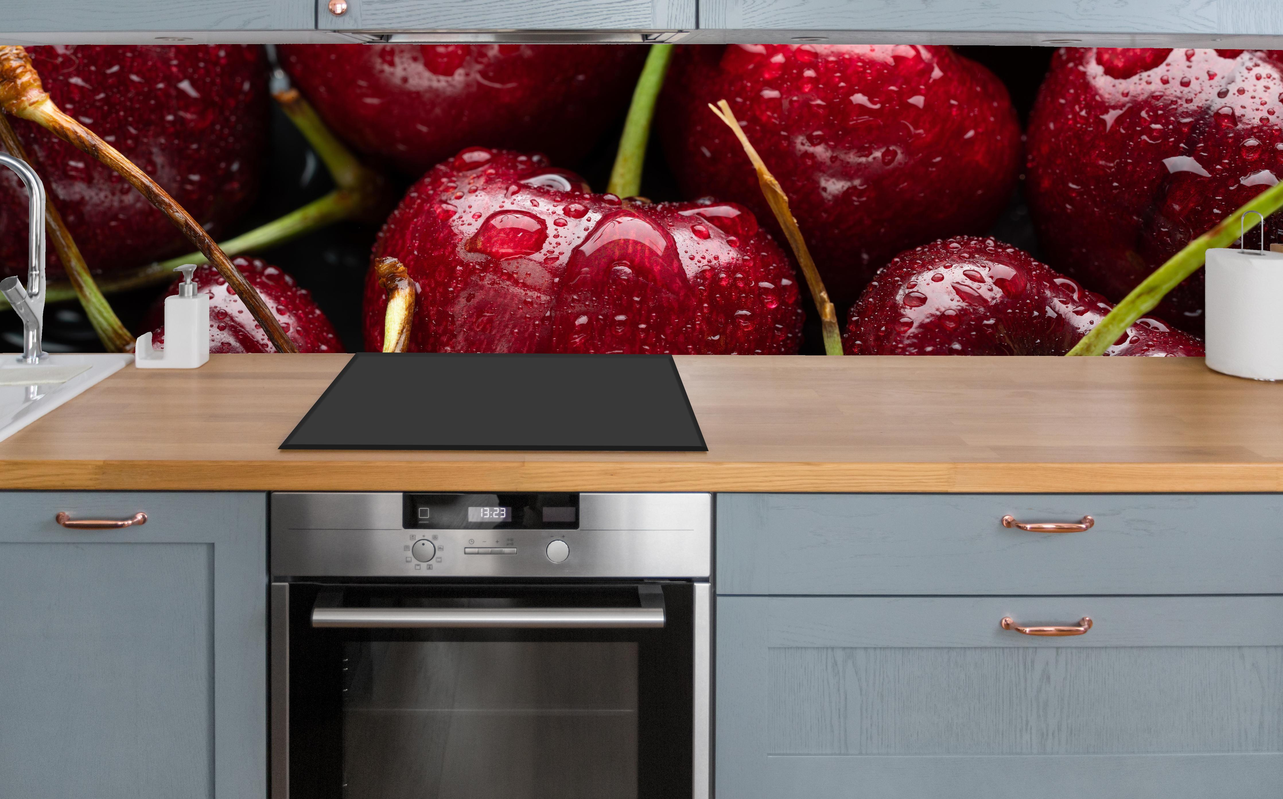 Küche - Kirschen mit Wasserperlen über polierter Holzarbeitsplatte mit Cerankochfeld
