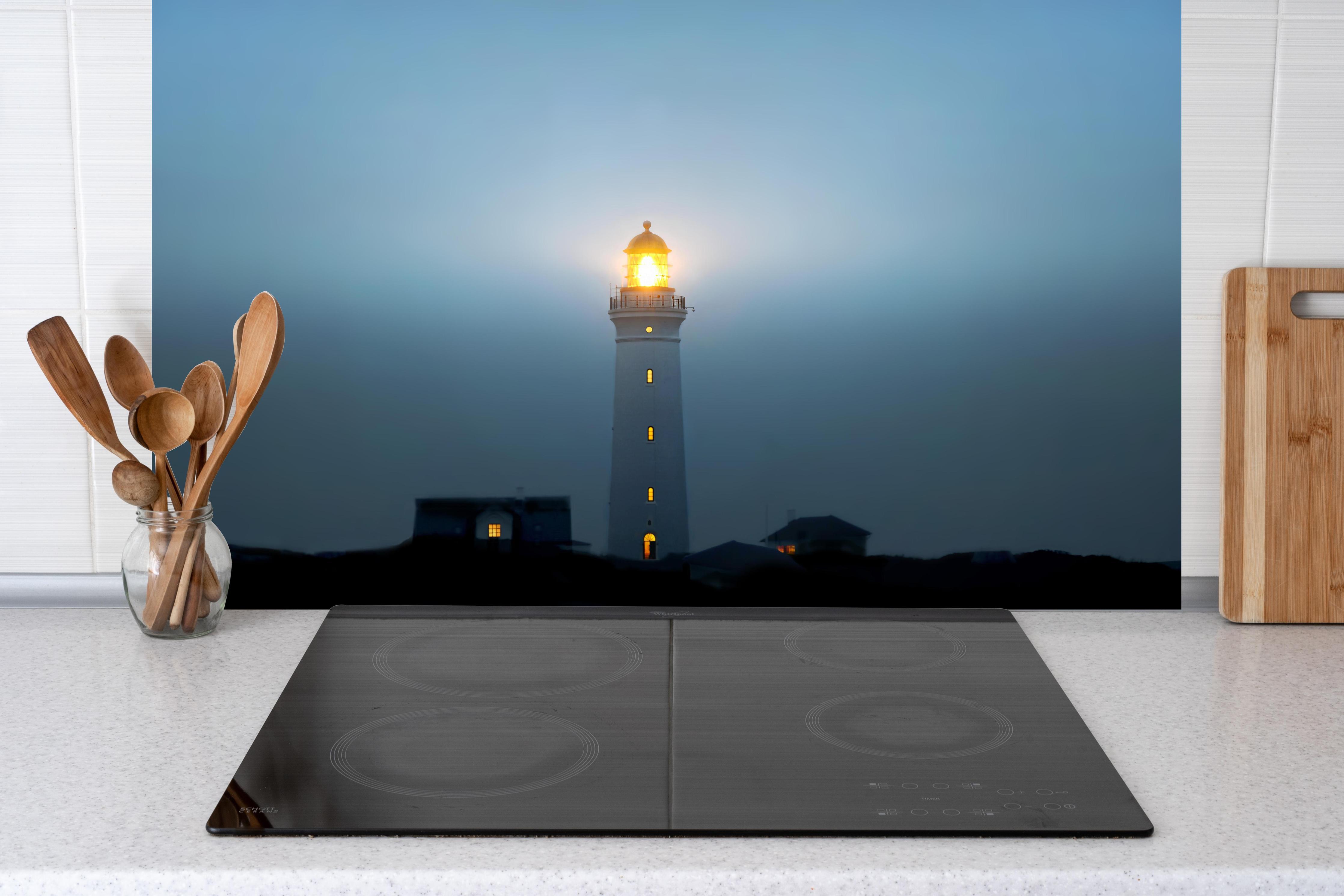 Küche - Leuchtturm im dunkeln hinter Cerankochfeld und Holz-Kochutensilien