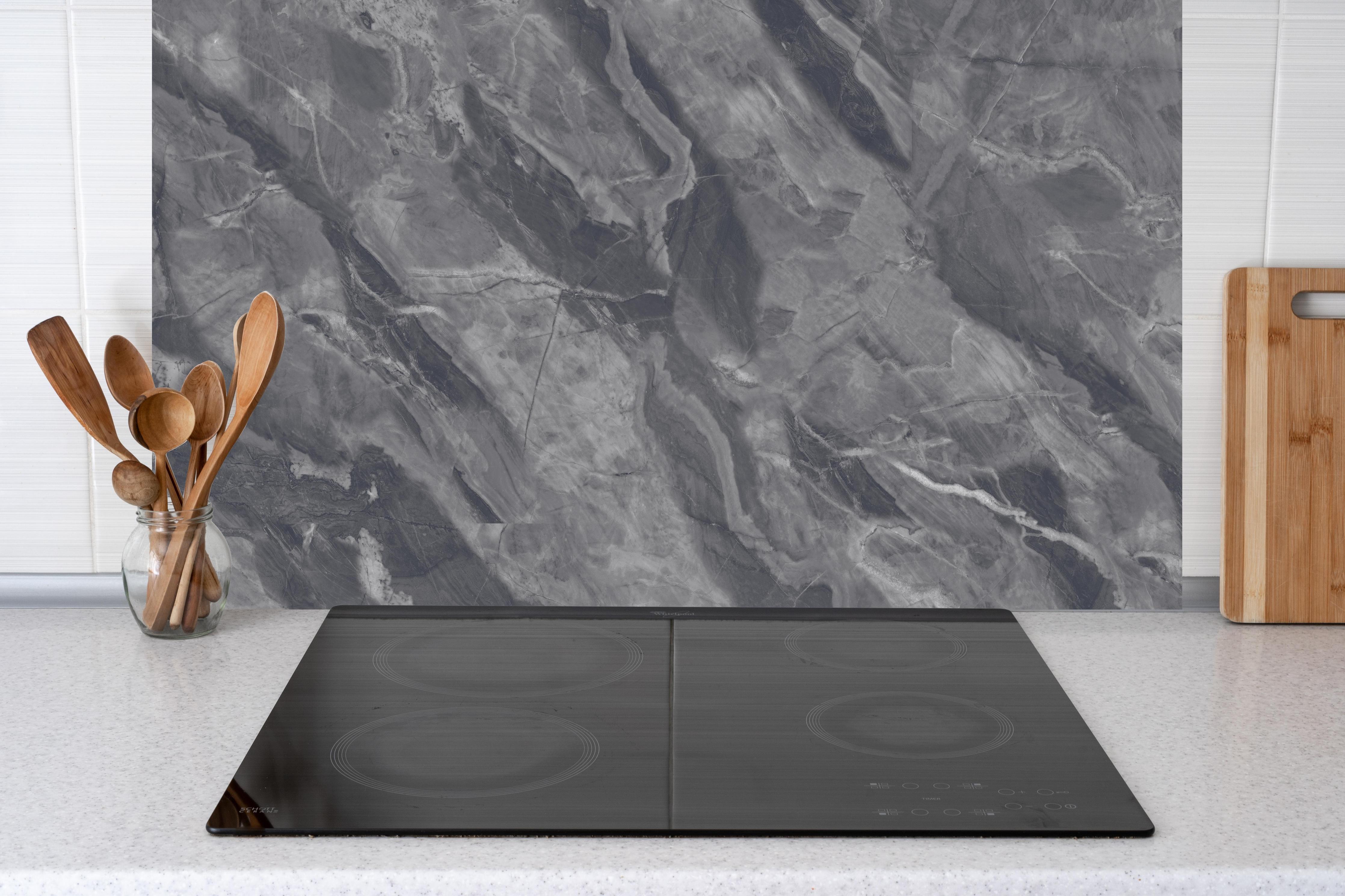 Küche - Natürliche Breccia-Marmorfliesen hinter Cerankochfeld und Holz-Kochutensilien