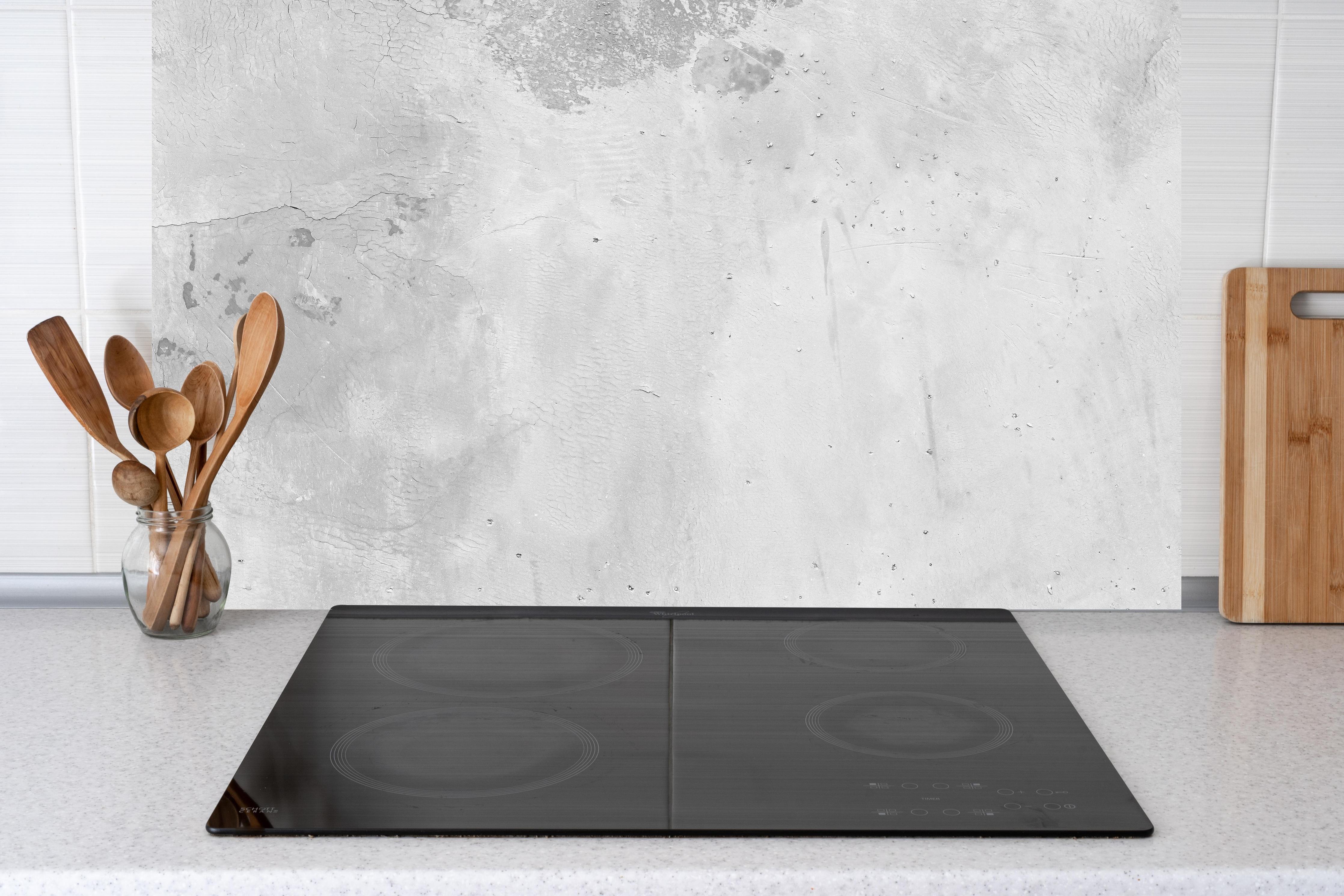 Küche - Panorama einer alten Betonwand hinter Cerankochfeld und Holz-Kochutensilien