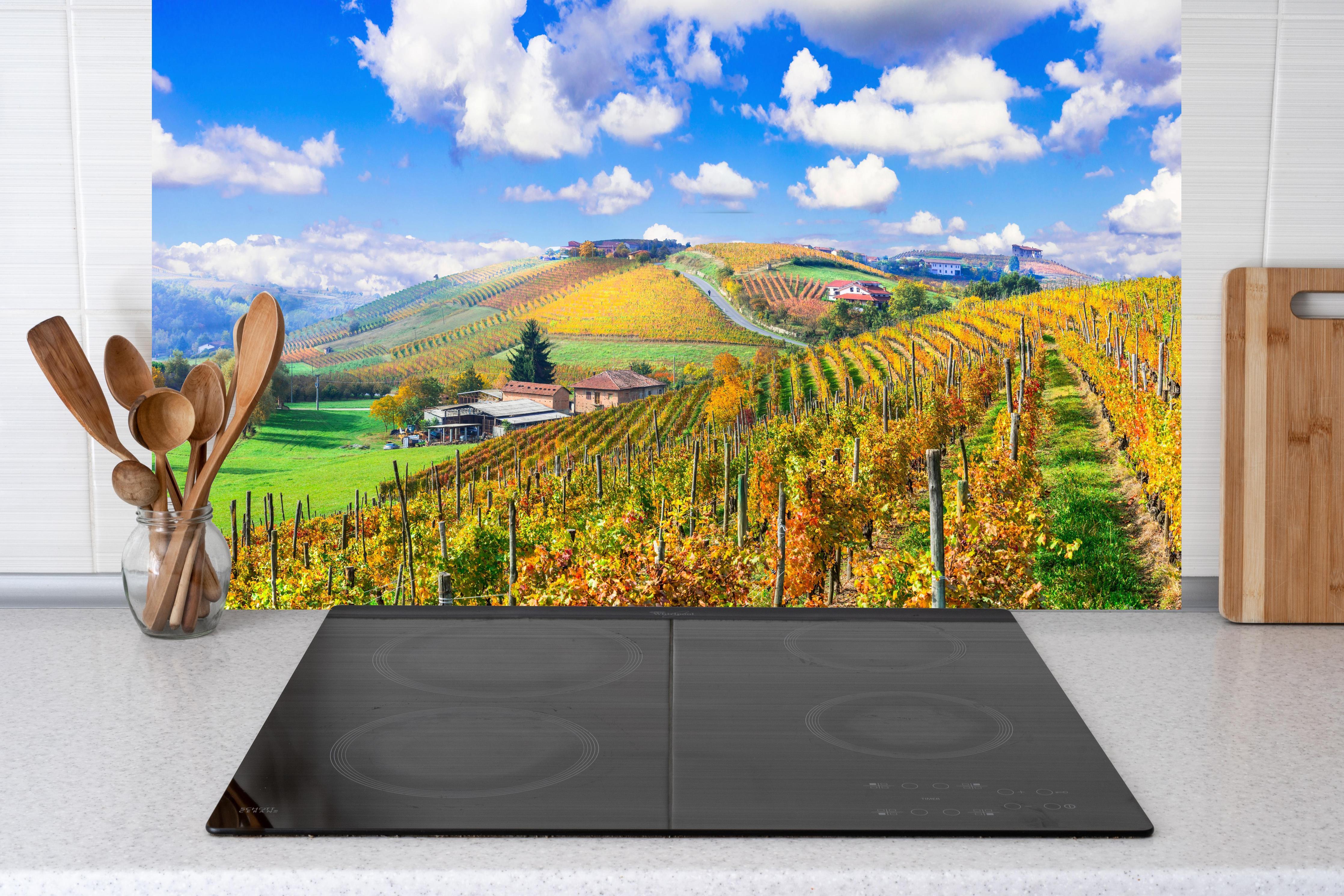 Küche - Schöne Herbstlandschaft mit Weinbergen - Toskana hinter Cerankochfeld und Holz-Kochutensilien