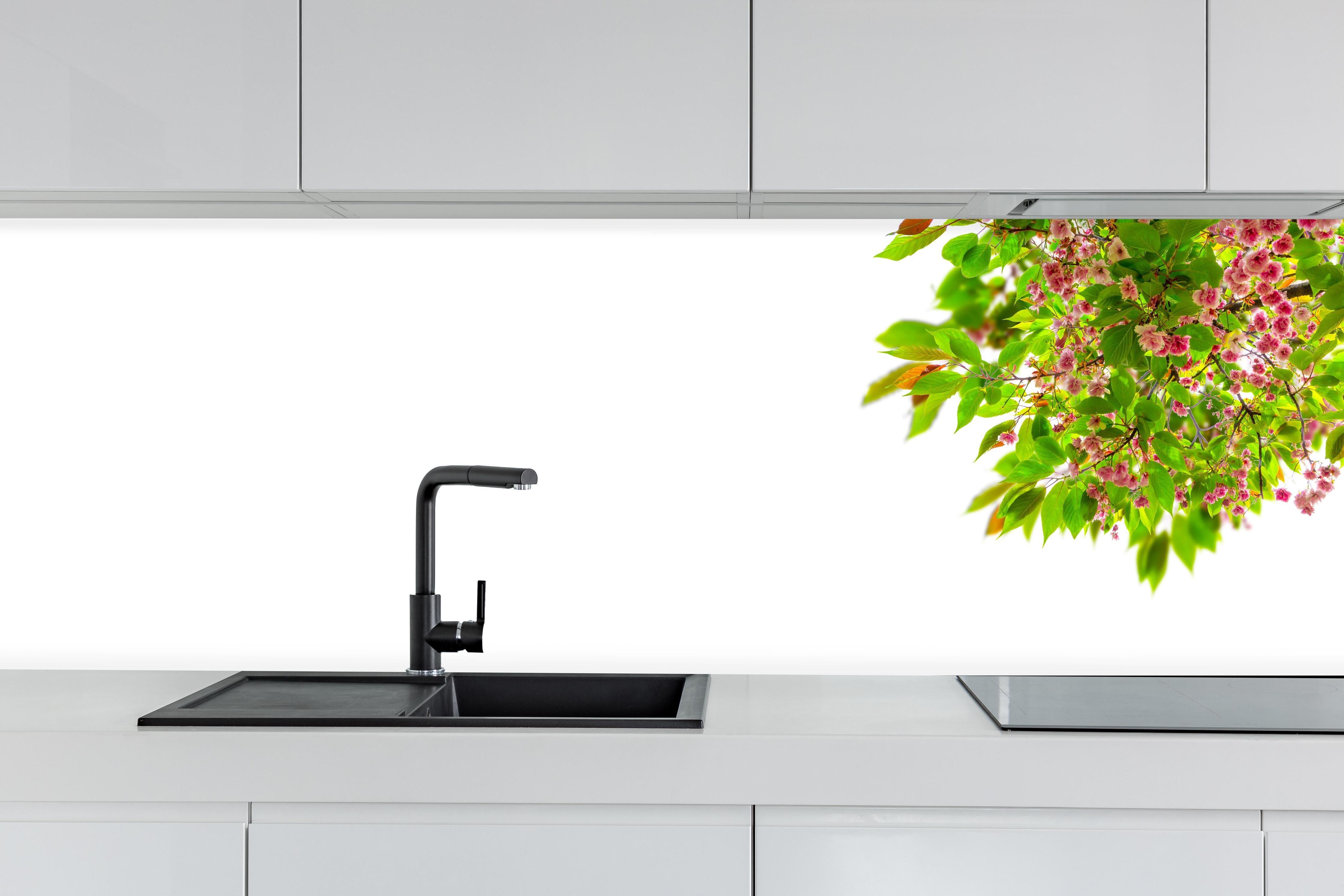 Küche - Schöner Kirschblütenast hinter weißen Hochglanz-Küchenregalen und schwarzem Wasserhahn