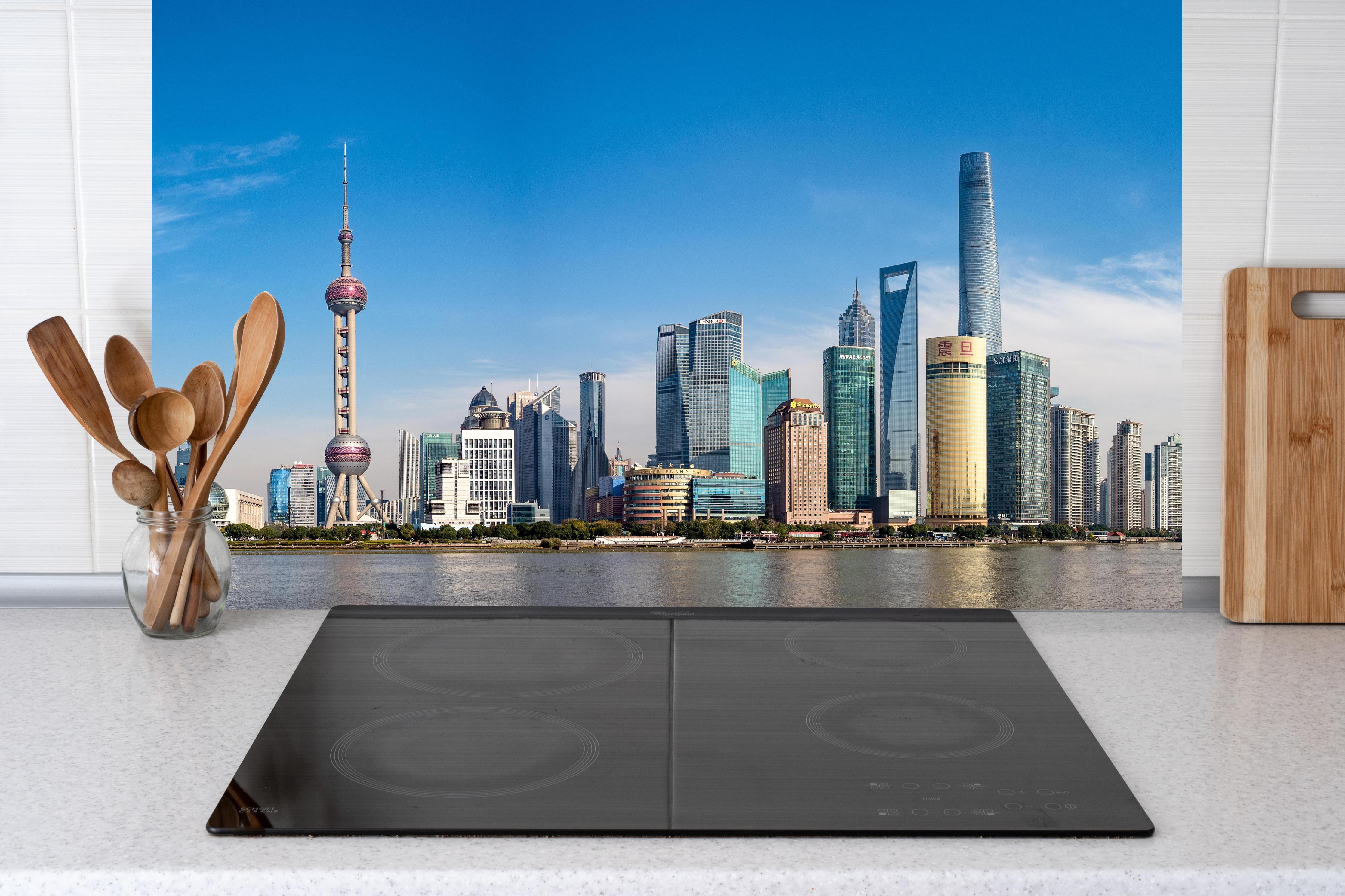 Küche - Skyline von Shanghai hinter Cerankochfeld und Holz-Kochutensilien