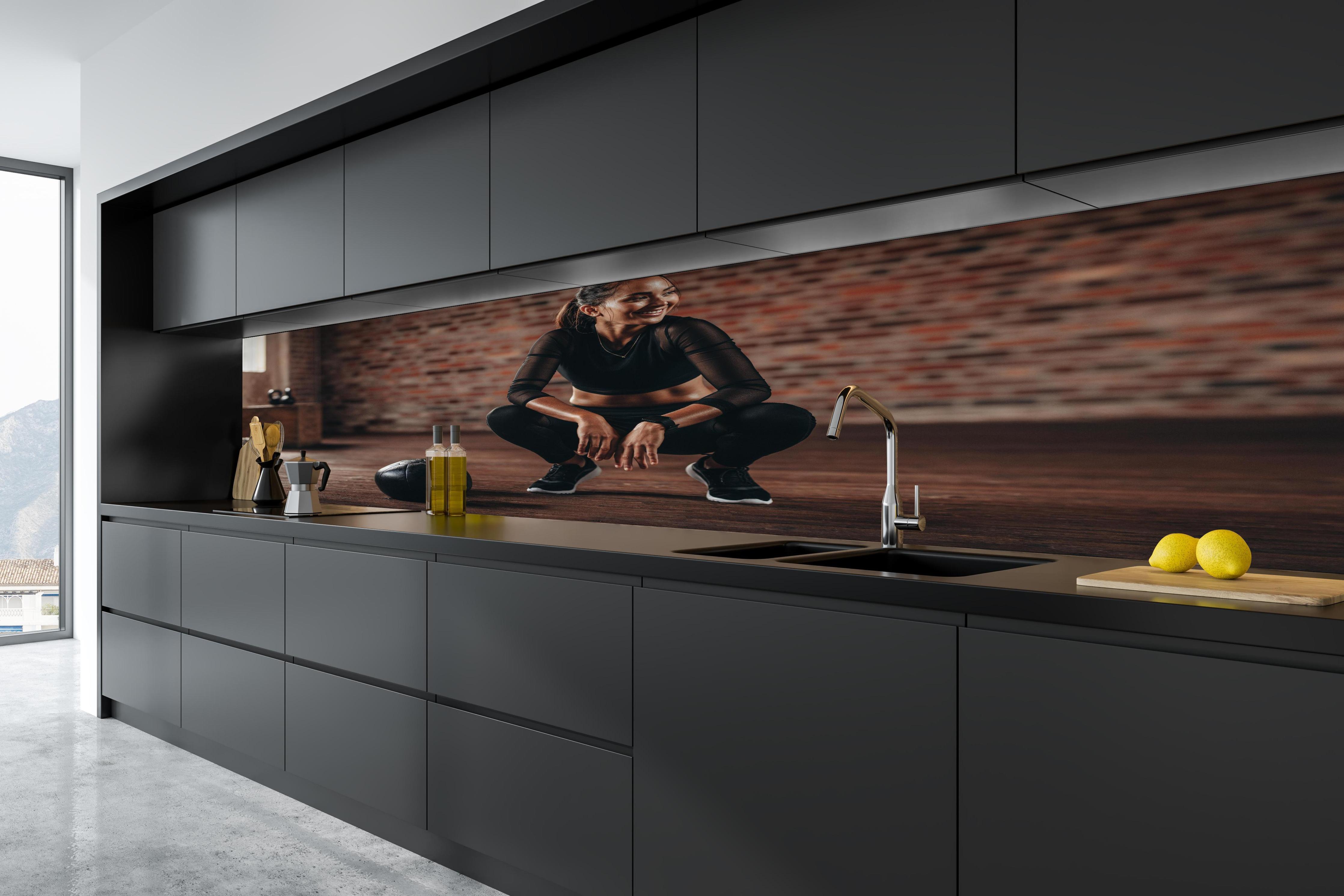Küche - Sportlerin in der Hocke in tiefschwarzer matt-premium Einbauküche