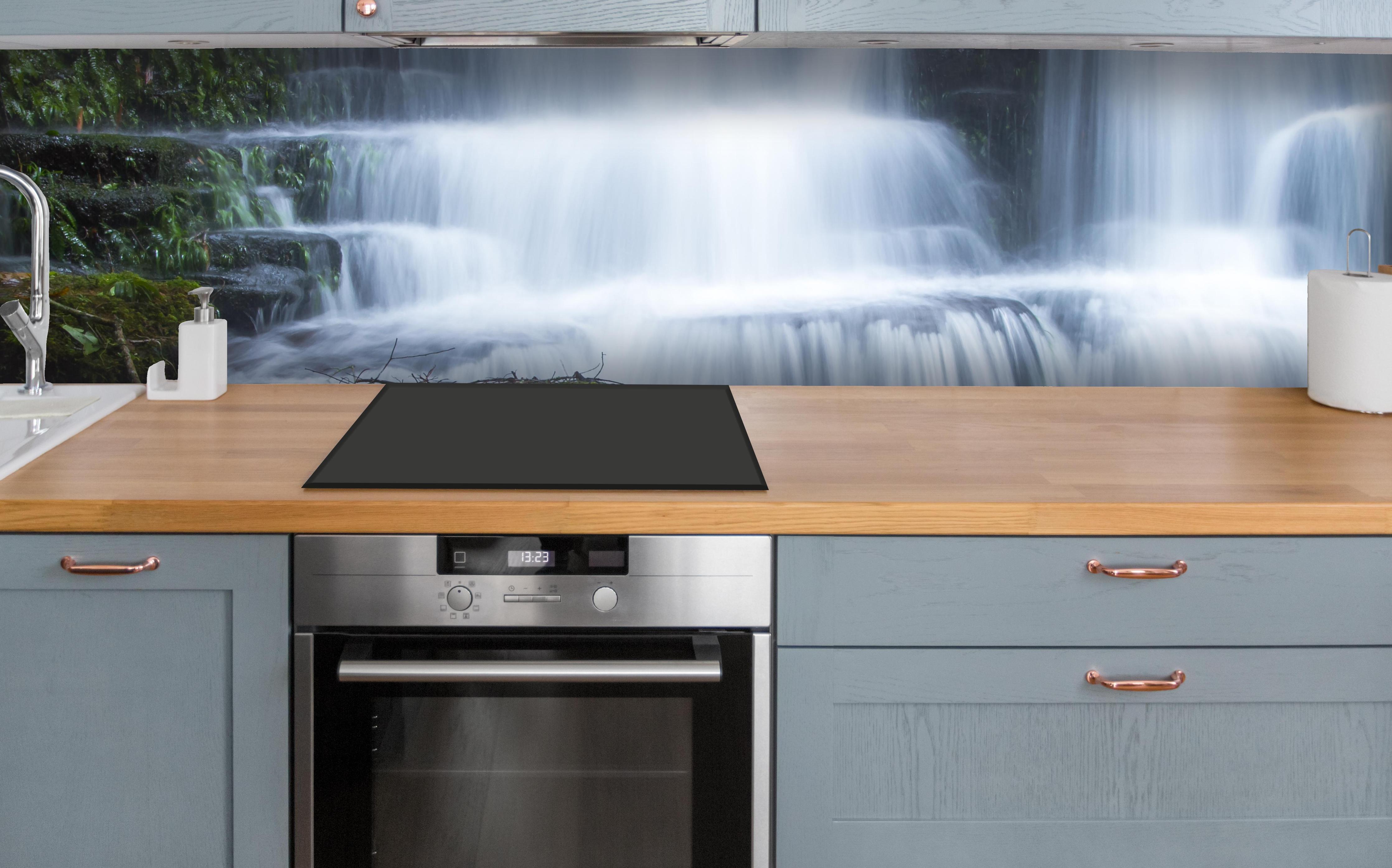 Küche - Wasserfall im Wald mit Felsen über polierter Holzarbeitsplatte mit Cerankochfeld