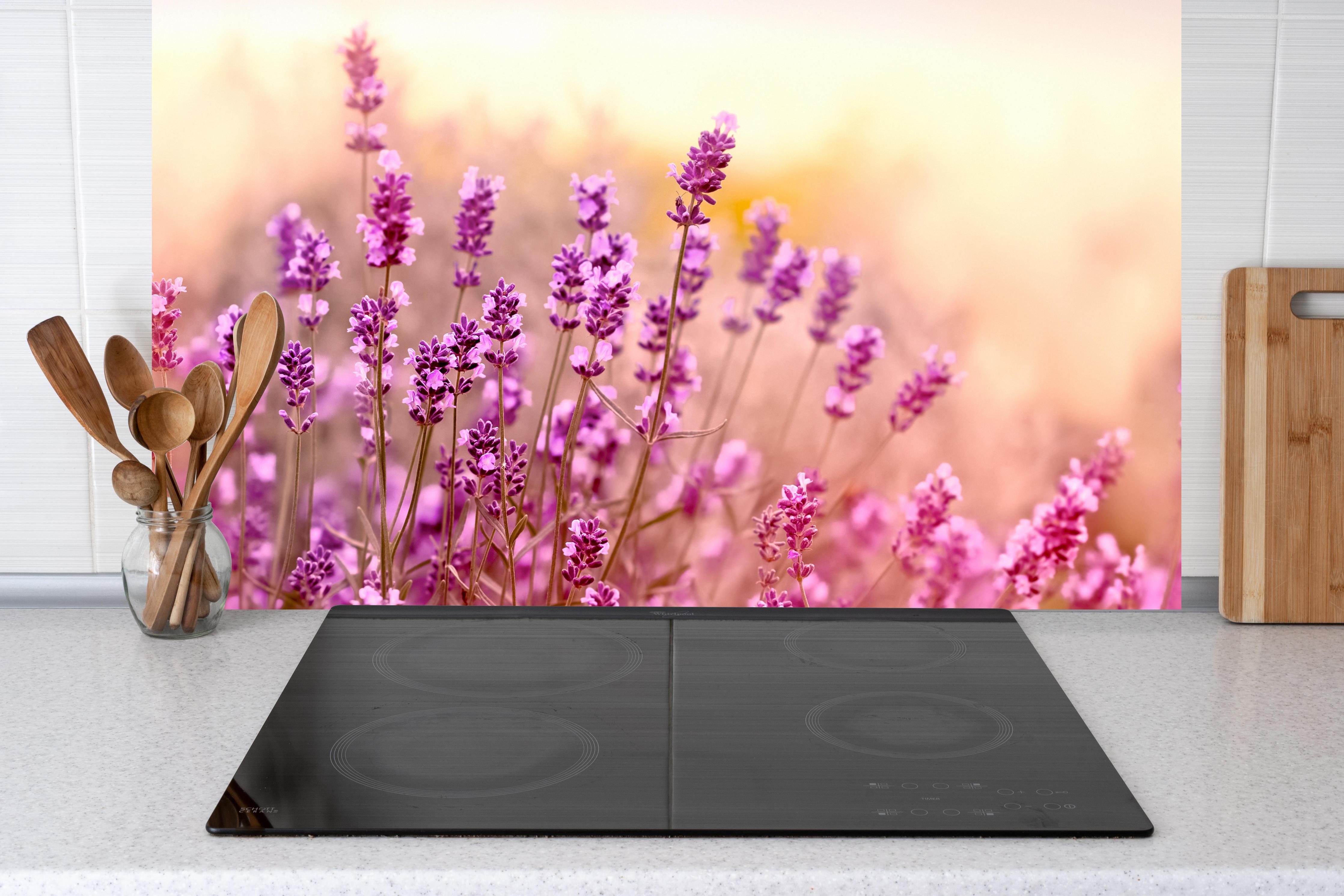 Küche - Weicher und selektiver Fokus auf Lavendelblüte hinter Cerankochfeld und Holz-Kochutensilien