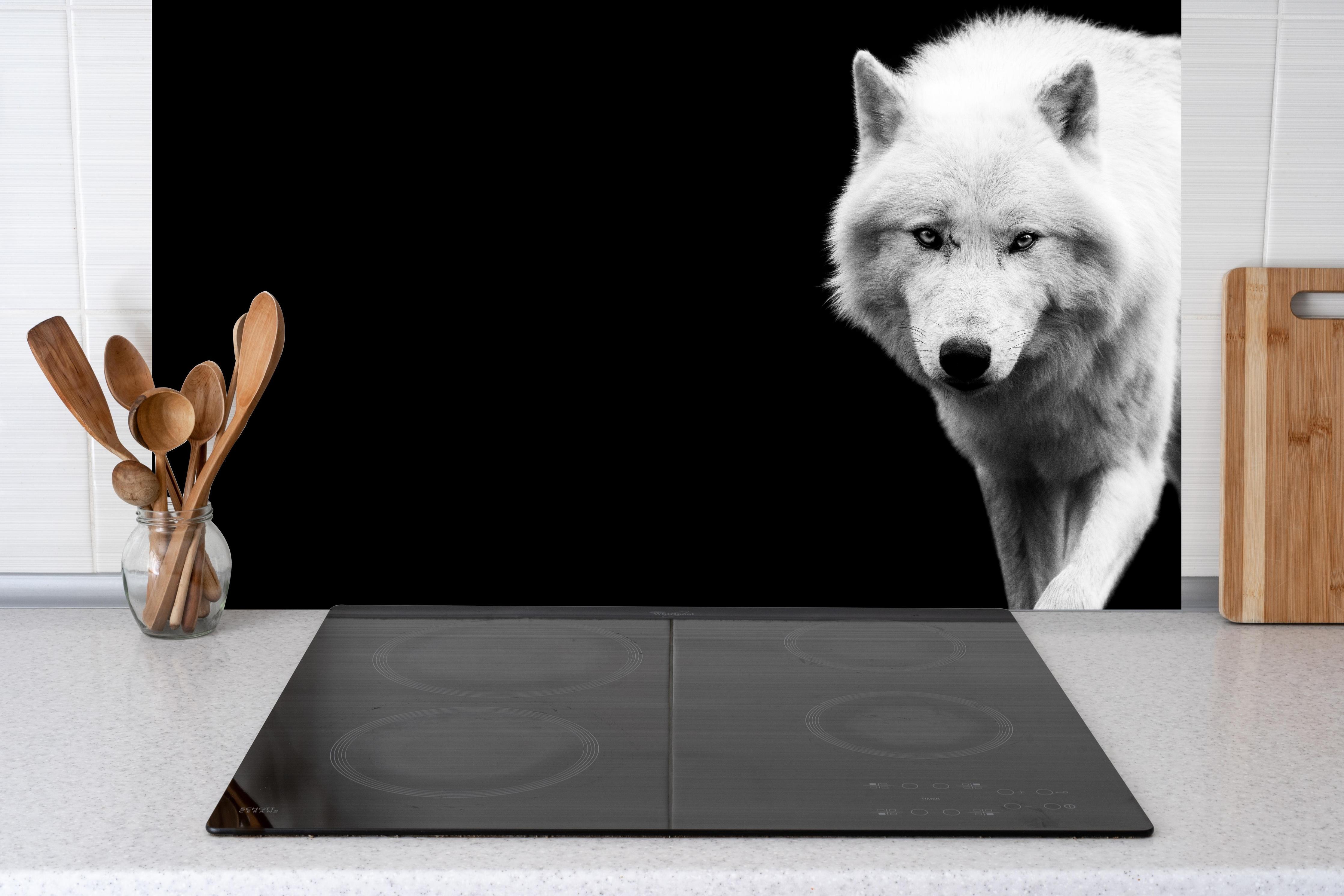 Küche - Weißer Wolf mit schwarzem Hintergrund hinter Cerankochfeld und Holz-Kochutensilien
