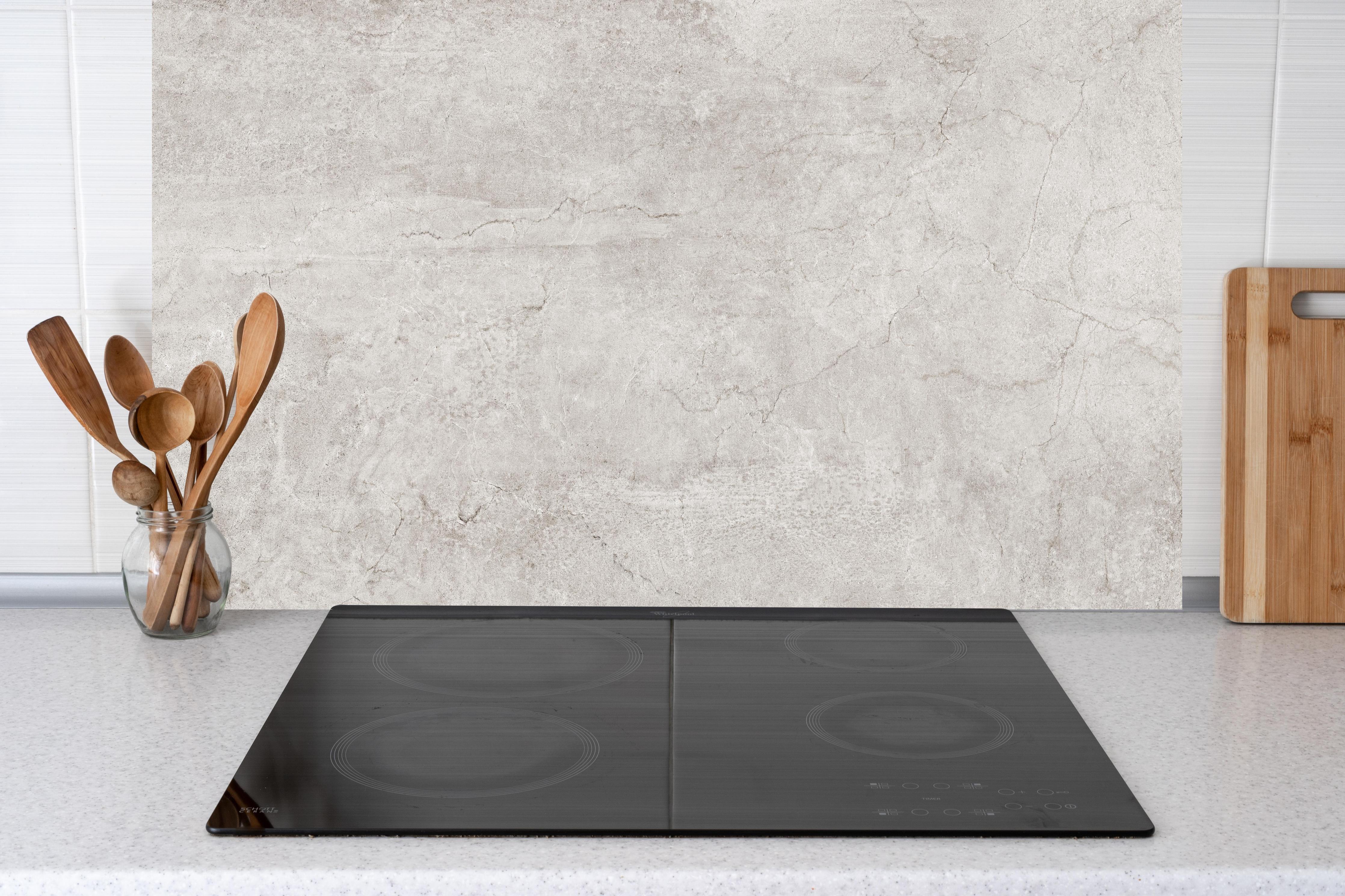 Küche - Weißliche Zement Textur hinter Cerankochfeld und Holz-Kochutensilien