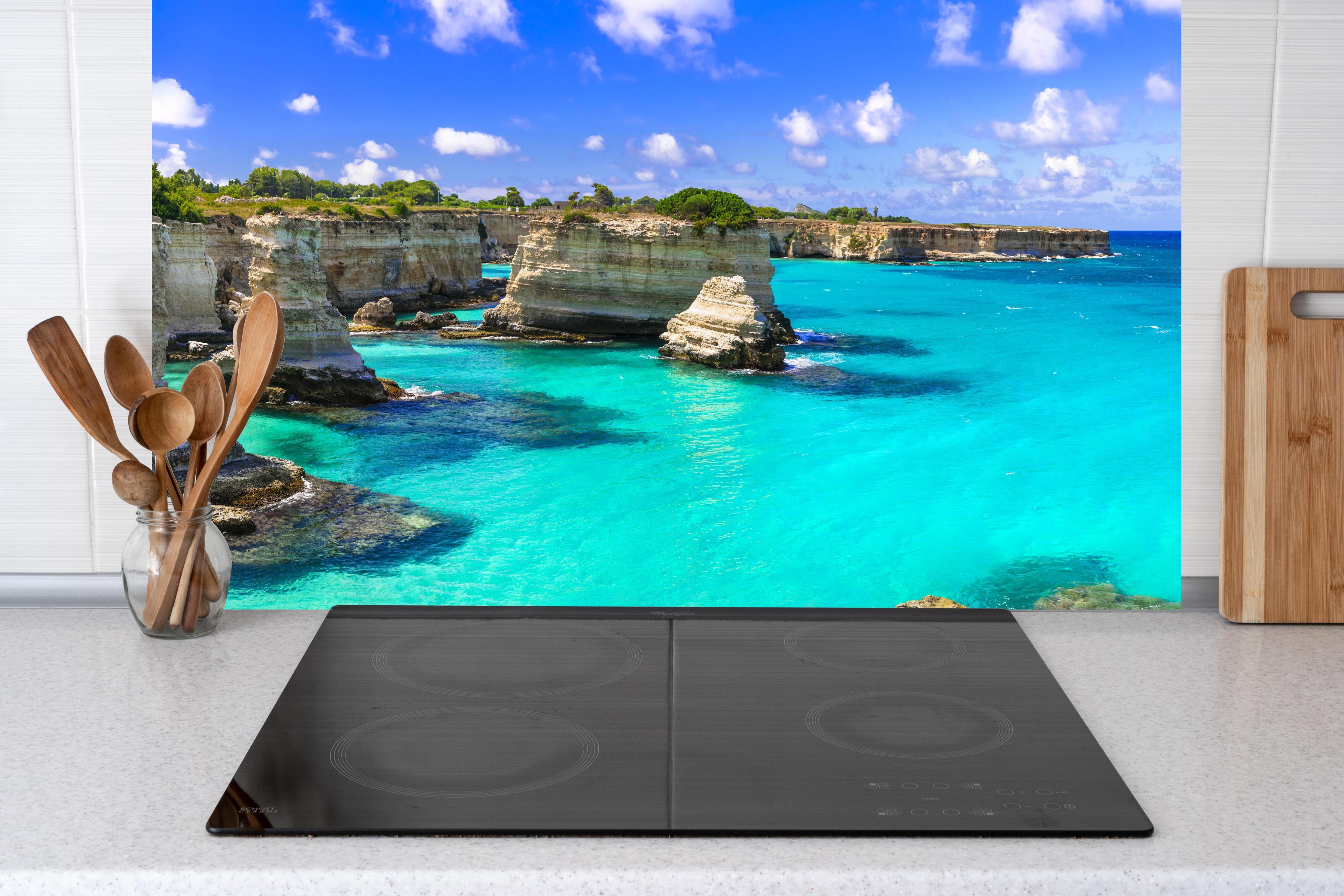 Küche - Wunderschöne Meereslandschaften in Apulien hinter Cerankochfeld und Holz-Kochutensilien