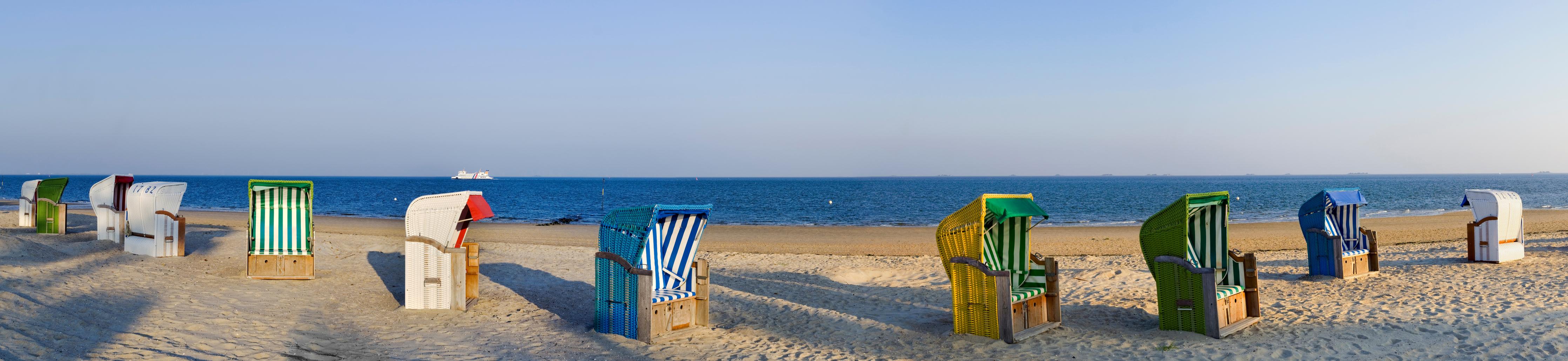 Küchenrückwand-Kunstvolle, bunte Strandkörbe am Sandstrand mit Blick aufs Meer
