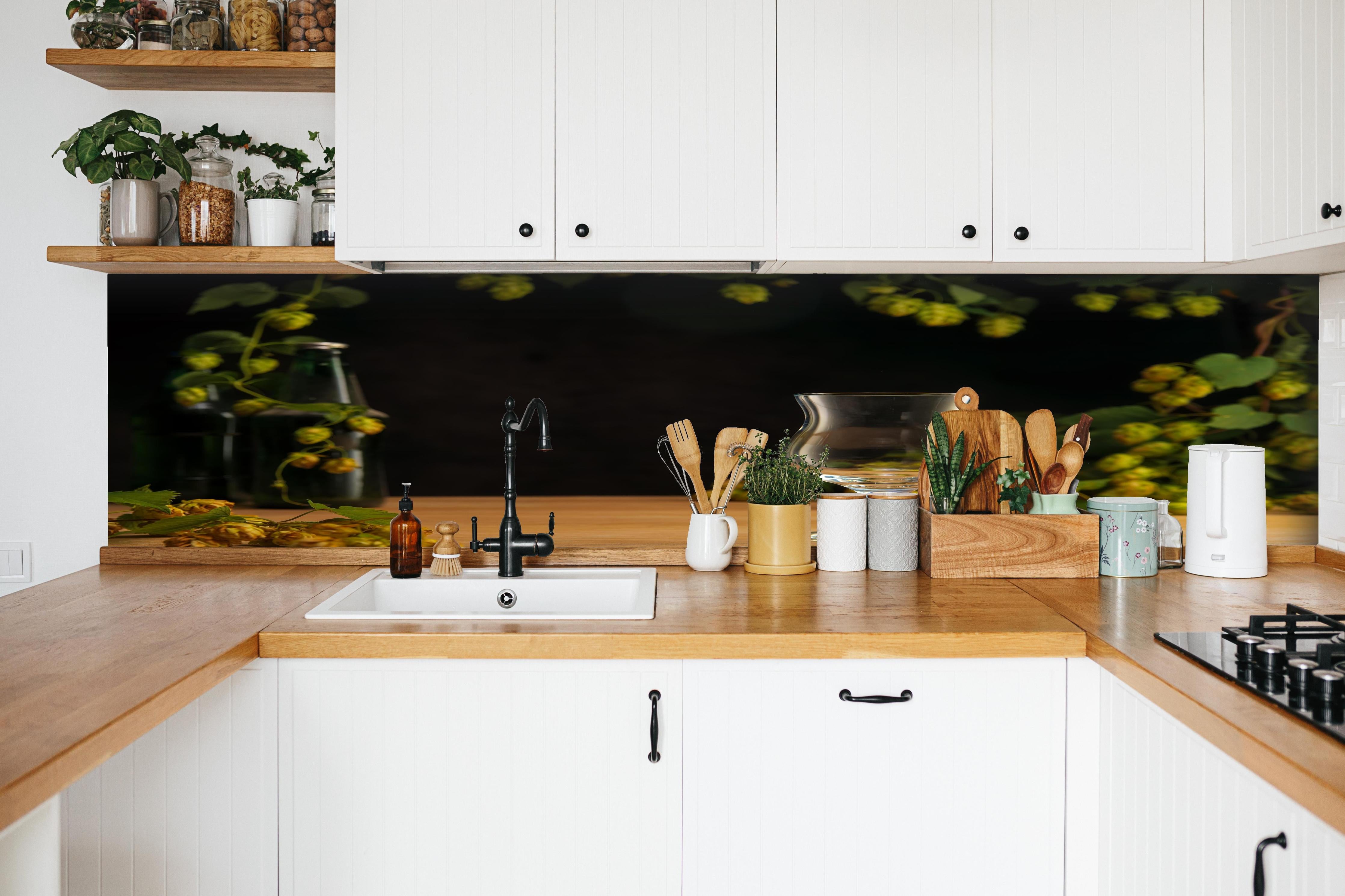 Küche - Leeres Tulpenglas auf Holztisch hinter weißen Hochglanz-Küchenregalen und schwarzem Wasserhahn