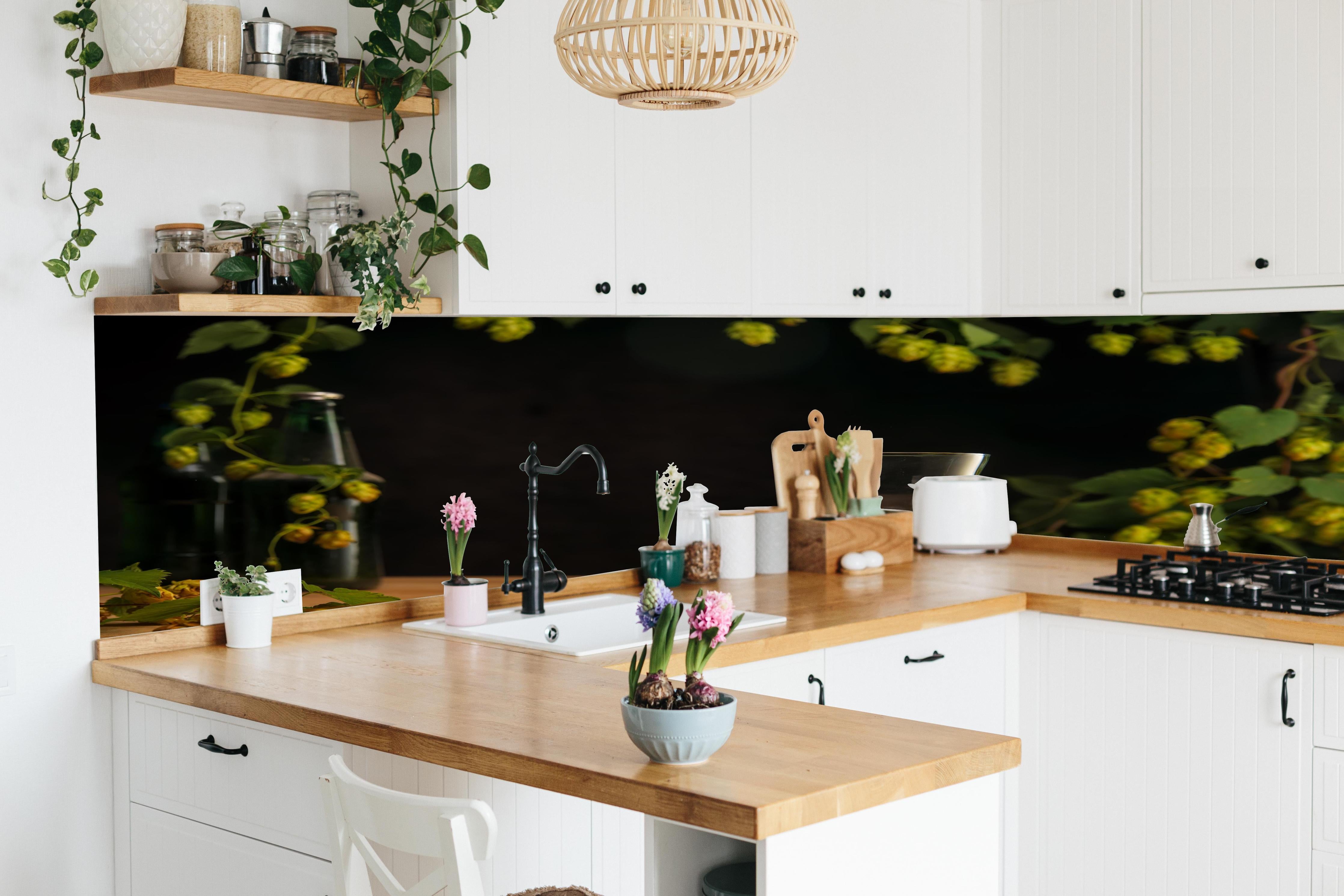 Küche - Leeres Tulpenglas auf Holztisch hinter weißen Hochglanz-Küchenregalen und schwarzem Wasserhahn