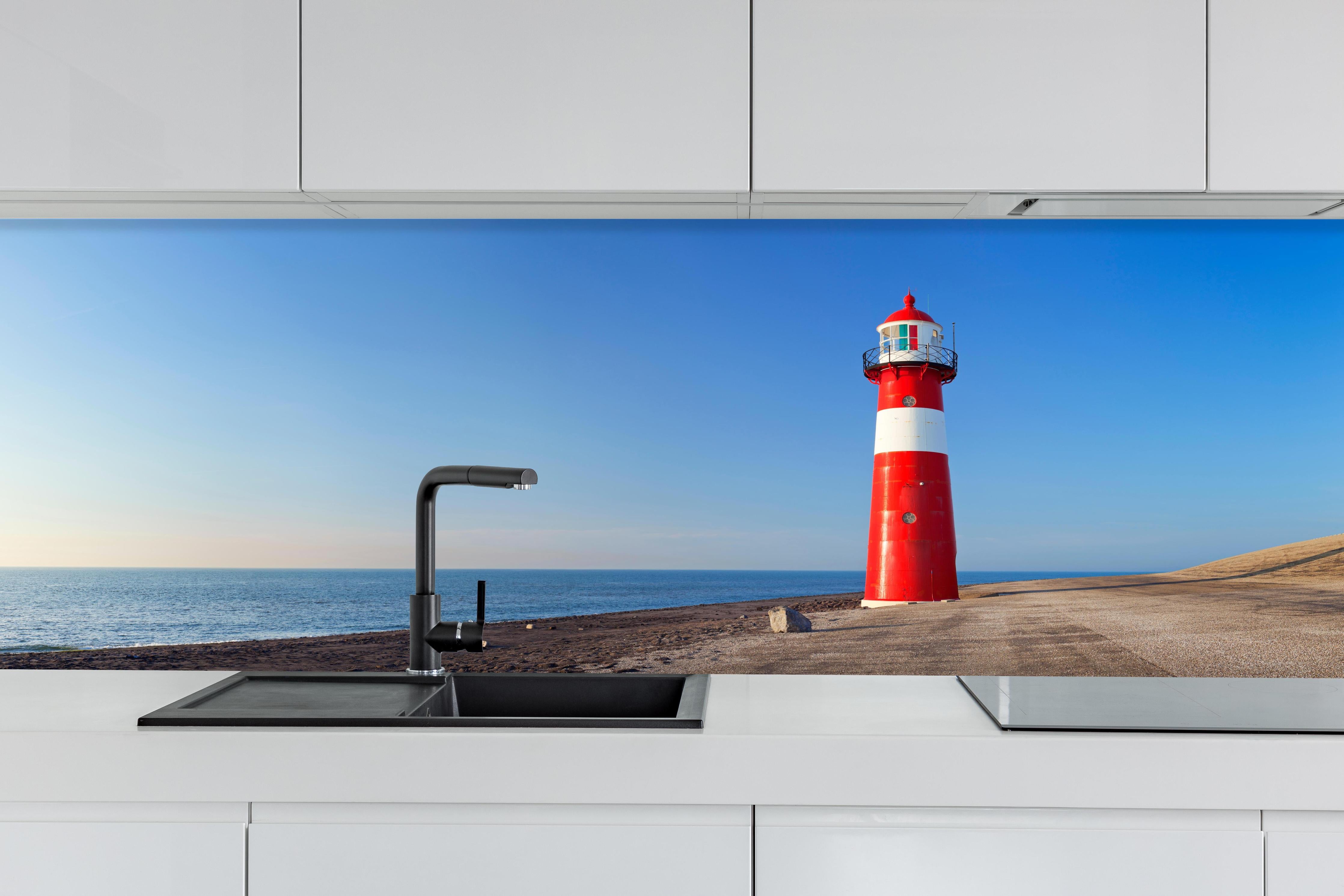 Küche - Leuchtturm in strahlendem Rot und Weiß vor weitem blauen Himmel hinter weißen Hochglanz-Küchenregalen und schwarzem Wasserhahn