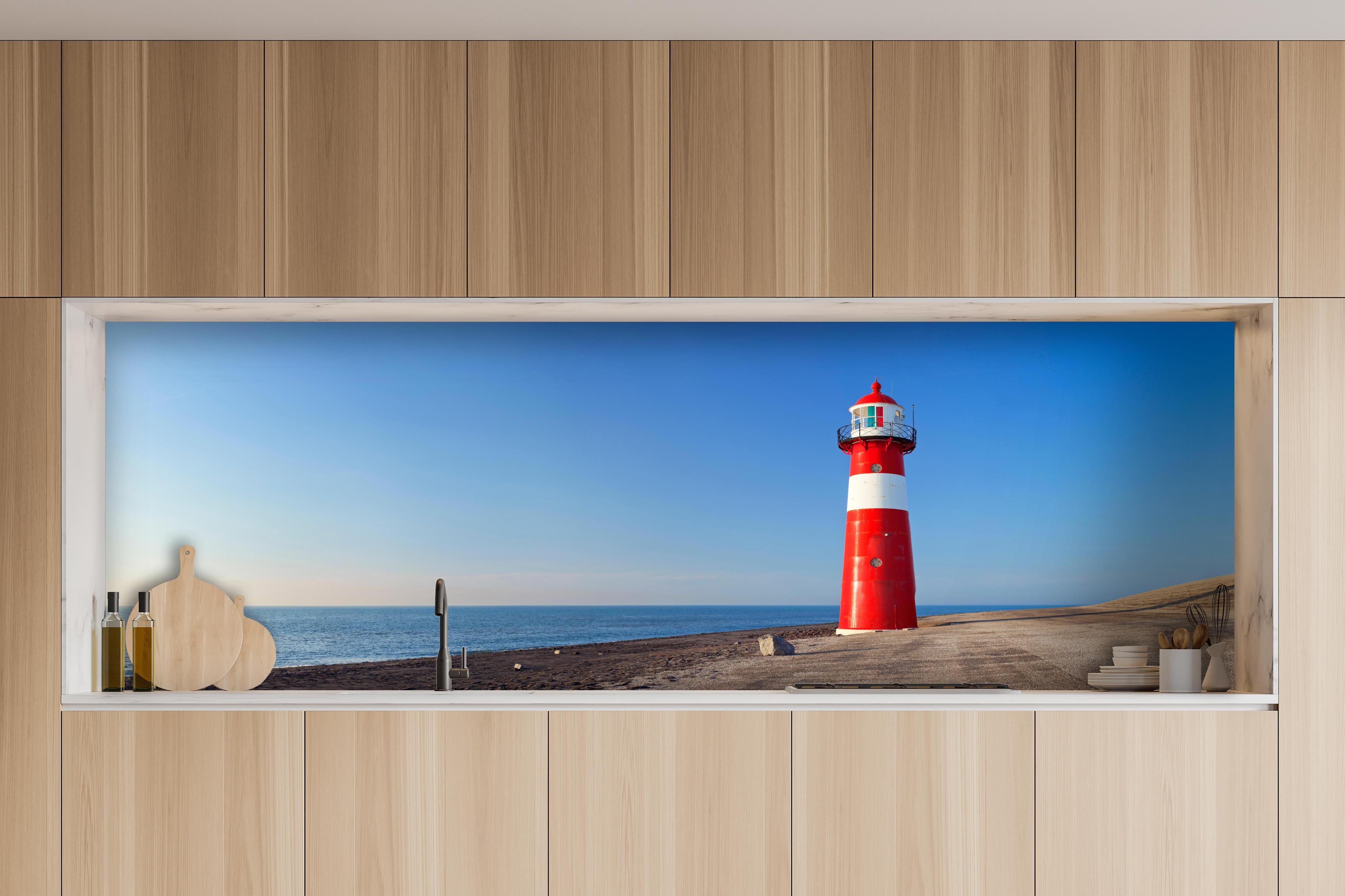 Küche - Leuchtturm in strahlendem Rot und Weiß vor weitem blauen Himmel hinter weißen Hochglanz-Küchenregalen und schwarzem Wasserhahn