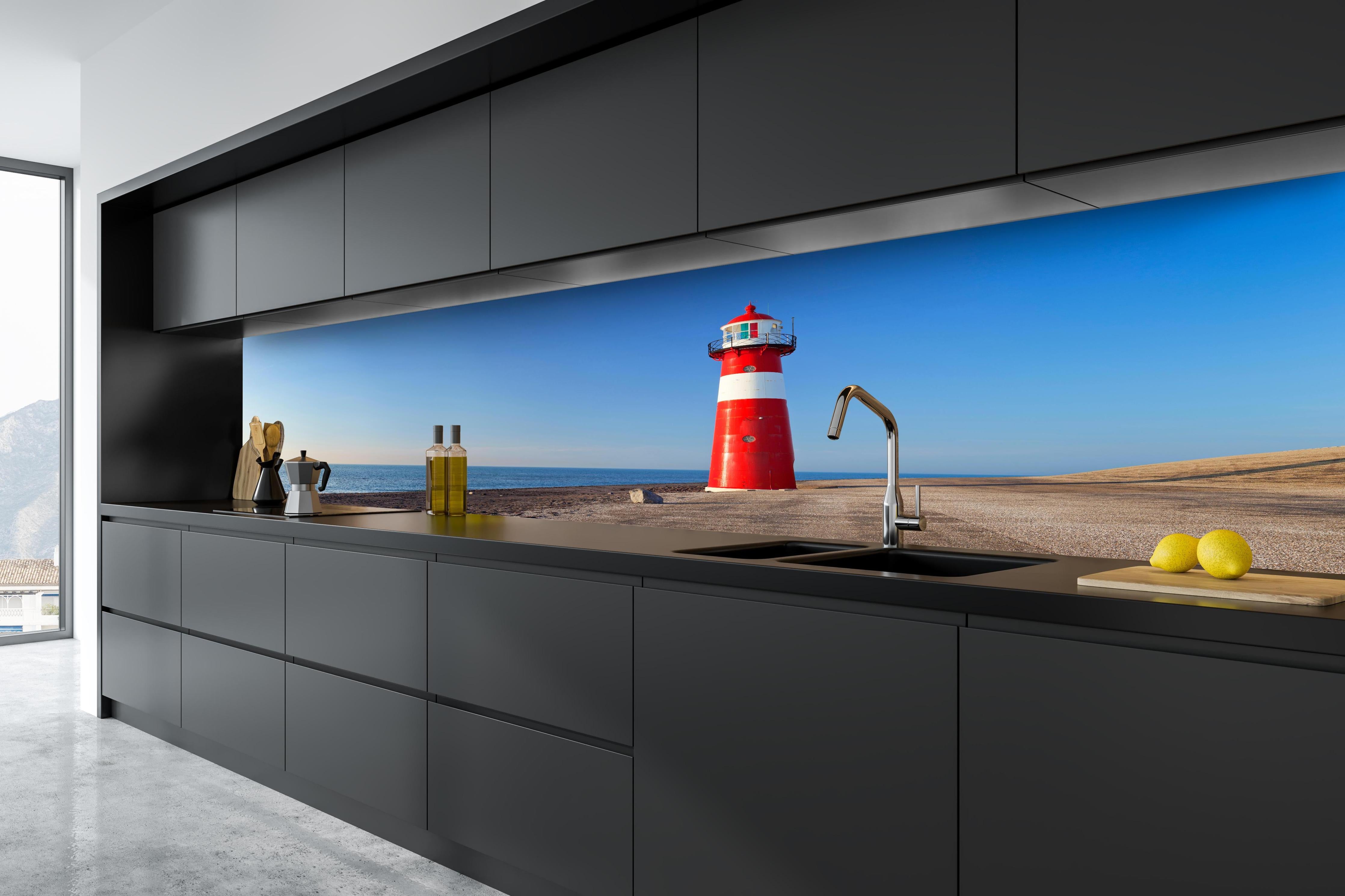 Küche - Leuchtturm in strahlendem Rot und Weiß vor weitem blauen Himmel hinter weißen Hochglanz-Küchenregalen und schwarzem Wasserhahn