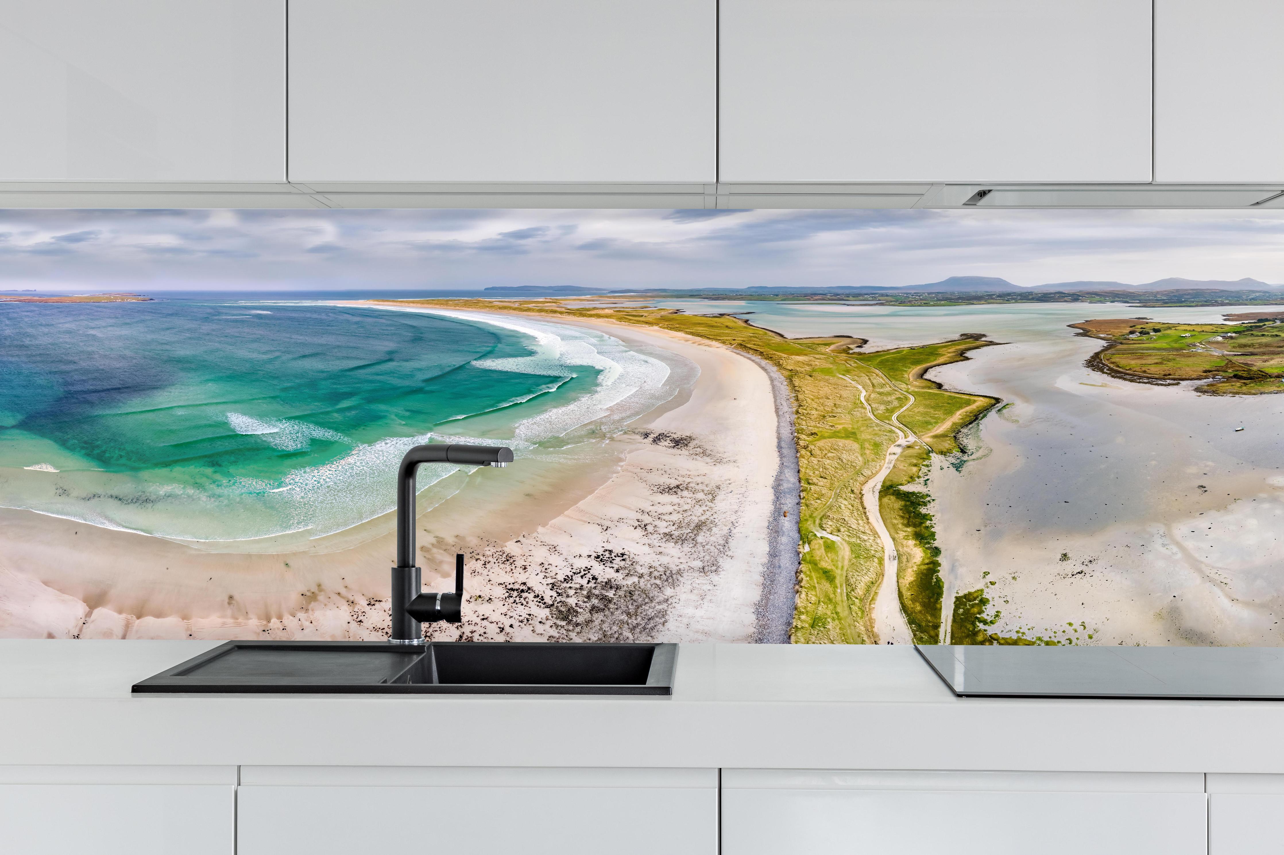 Küche - Luftaufnahme der Küste von Magheraroarty-Irland hinter weißen Hochglanz-Küchenregalen und schwarzem Wasserhahn